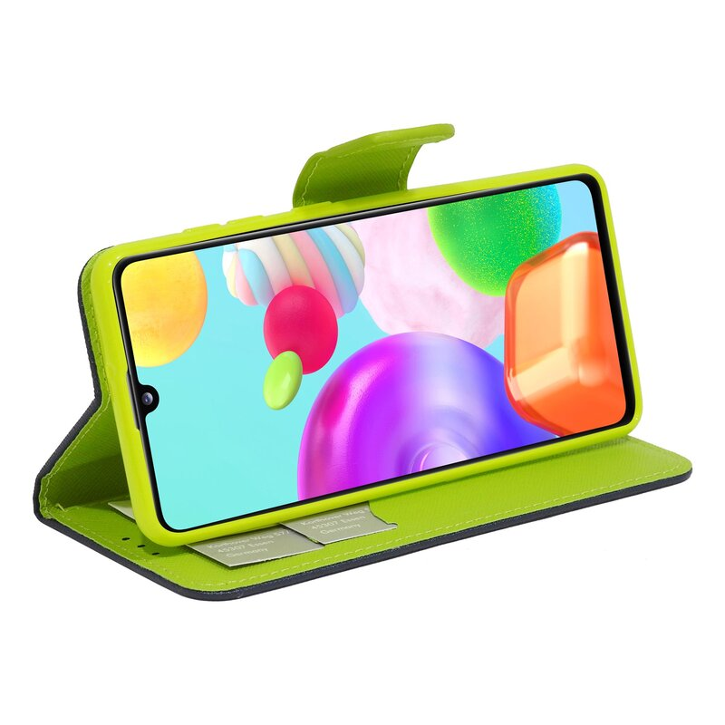 Grüne Handyhülle mit farbigen Grafiken auf dem Handy, auf weißer Oberfläche.