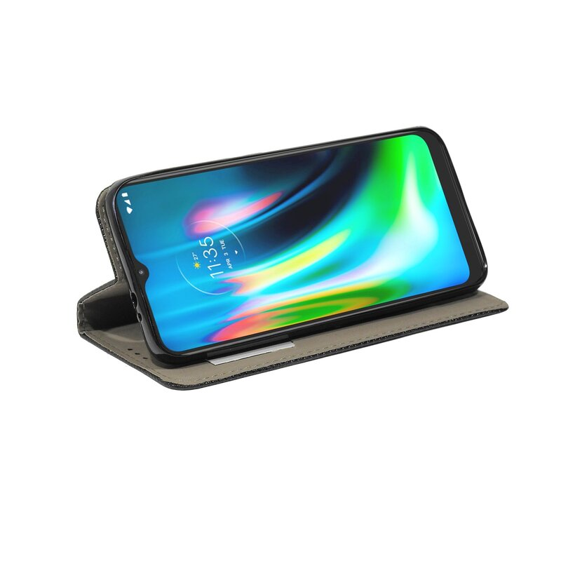 Smartphone in einer schwarz-grauen Hülle, angewinkelt auf weißer Oberfläche geöffnet.