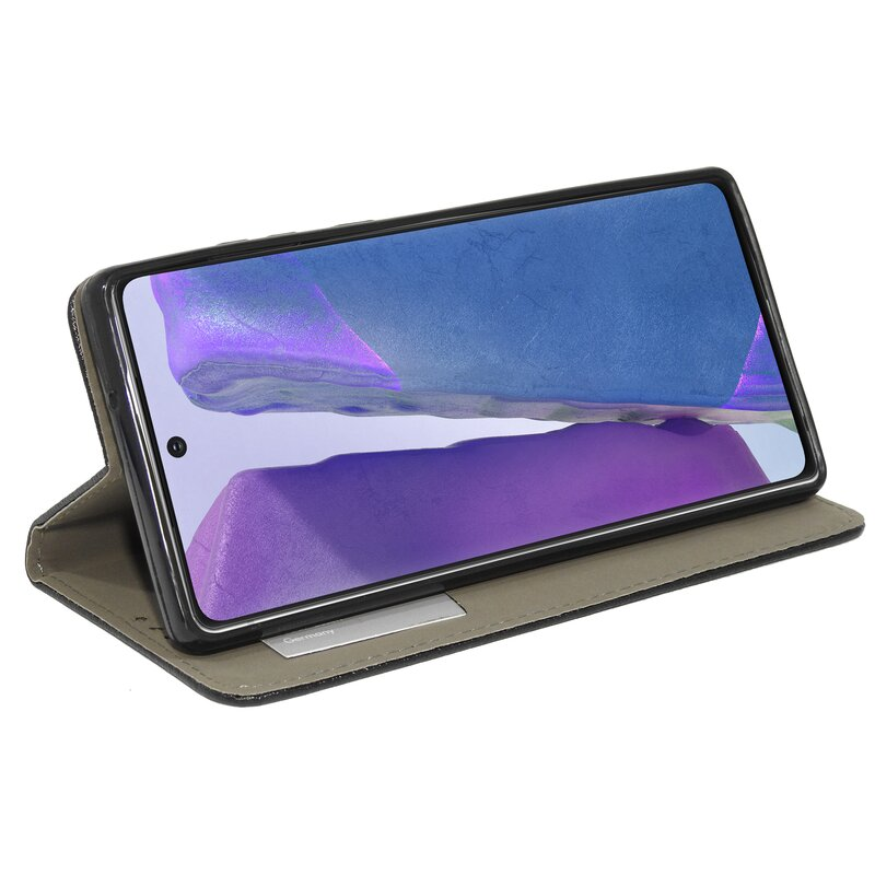 Schwarzes Telefon in schwarzer Hülle, geöffnet, mit blauem Bildschirm. Grauer Hintergrund.