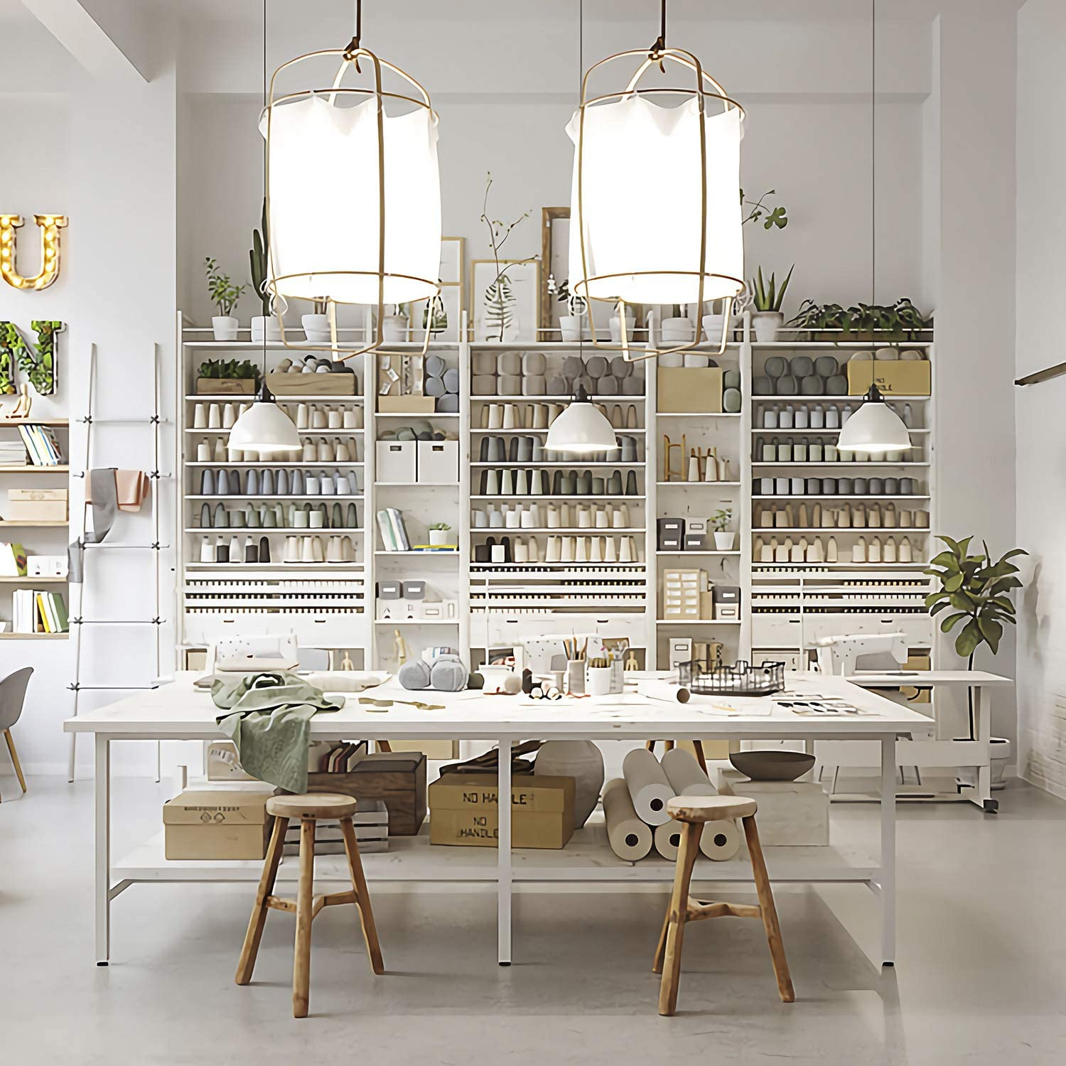 Una stanza per hobby luminosa e ben organizzata con scaffali di forniture, un grande tavolo e macchine da cucire.