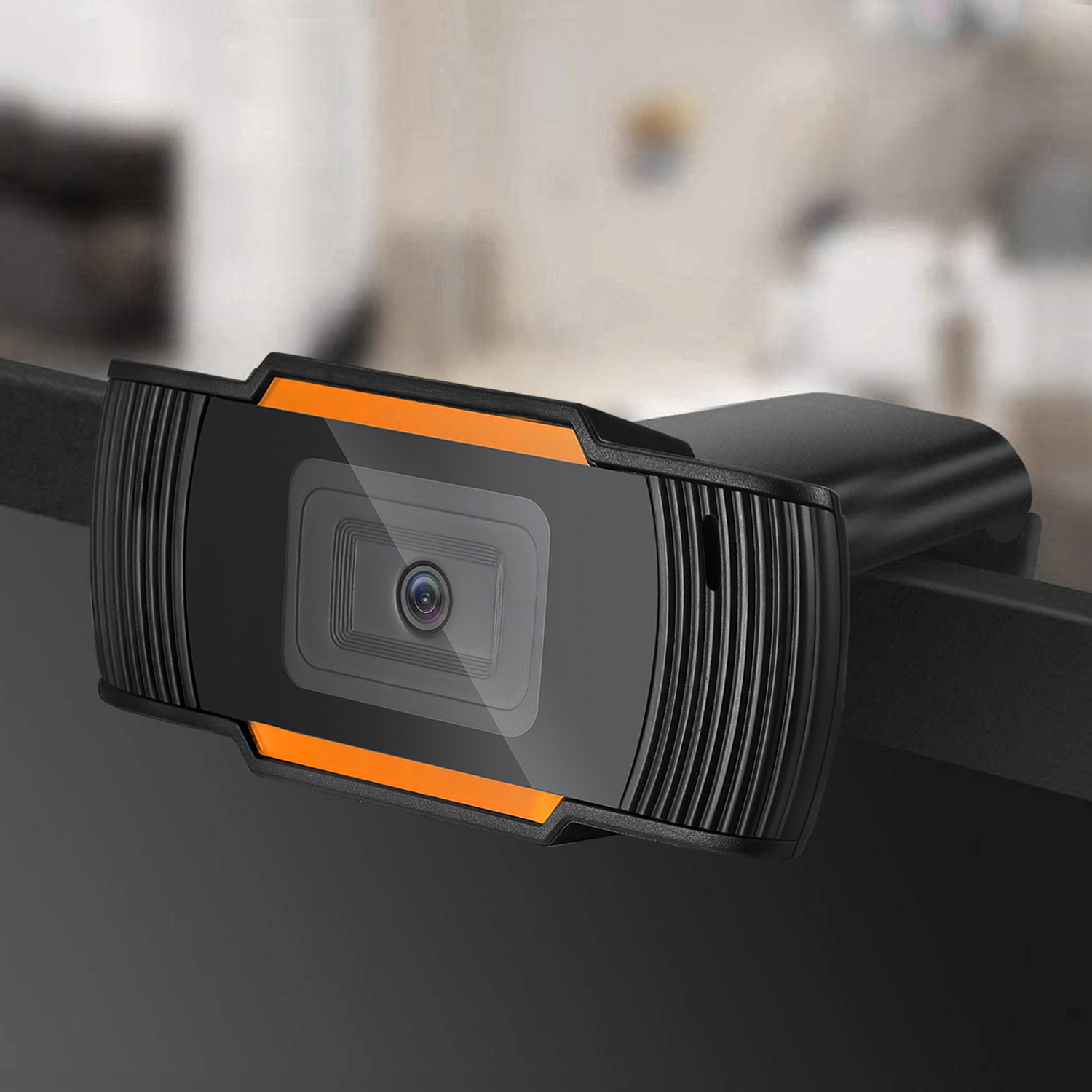 Schwarz-orange Webcam auf einem Schreibtisch, zum Betrachter geneigt.