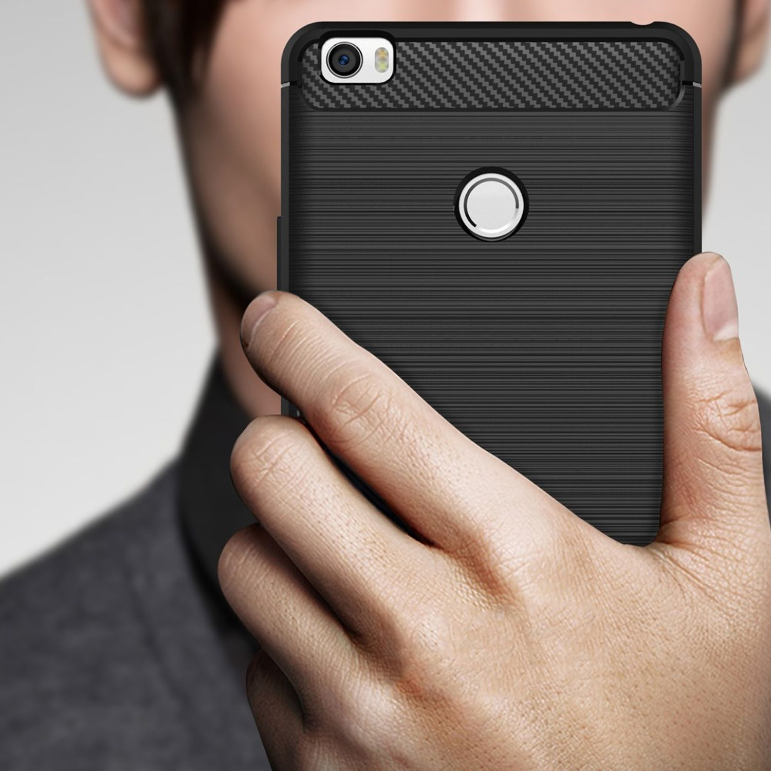 Eine Hand, die eine schwarze Handyhülle mit Kohlefasermuster hält. Das Telefon ist sichtbar.