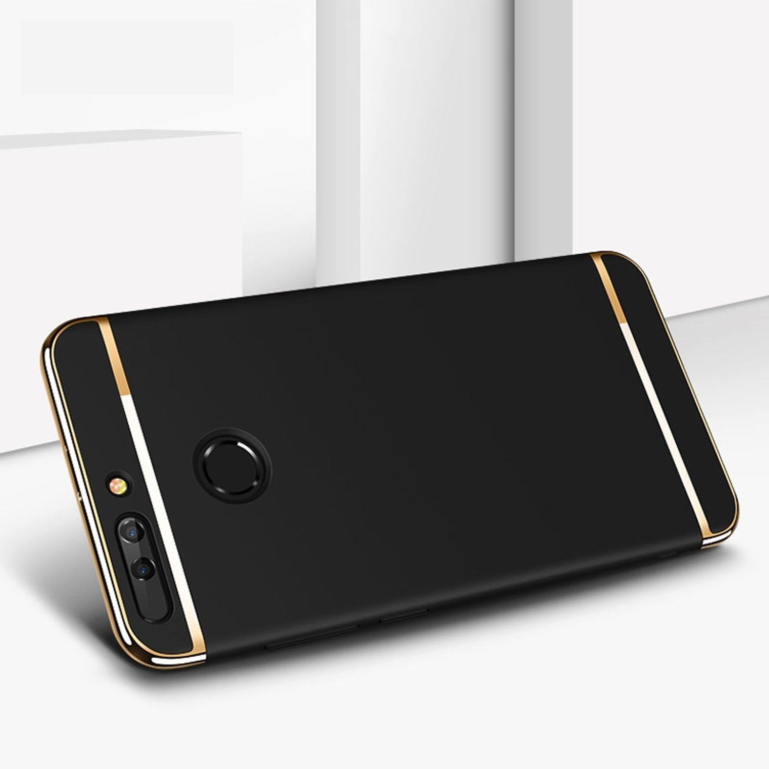 Schwarzes Telefon mit goldenen Rändern. Rückansicht auf weißer Oberfläche.