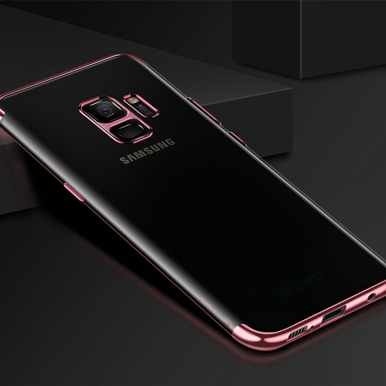 Schwarzes Telefon mit pinkfarbenem Rahmen. Das Telefon liegt auf einer schwarzen Oberfläche, mit Samsung-Logo. Die Kamera ist sichtbar.