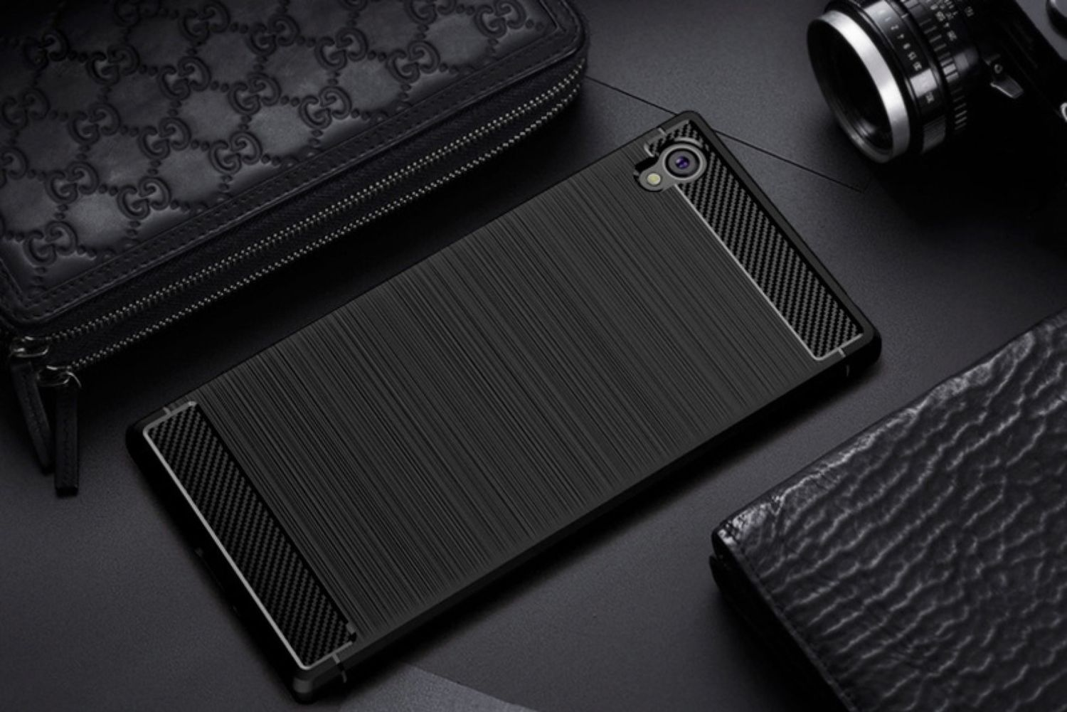 Schwarze Handyhülle mit einem Telefon darin. Schwarzer Hintergrund, mehrere Accessoires im Hintergrund.