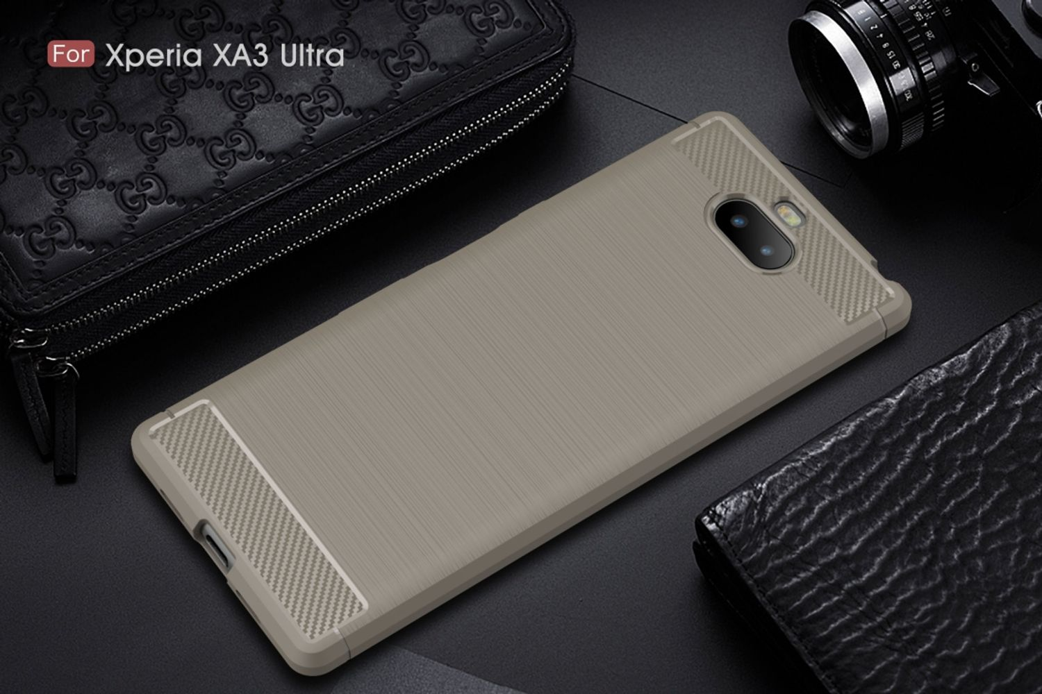 Eine graue Handyhülle mit strukturierter Rückseite auf dunkler Oberfläche. Eine Geldbörse und eine Kamera stehen daneben. Text: 'Für Xperia XA3 Ultra'.