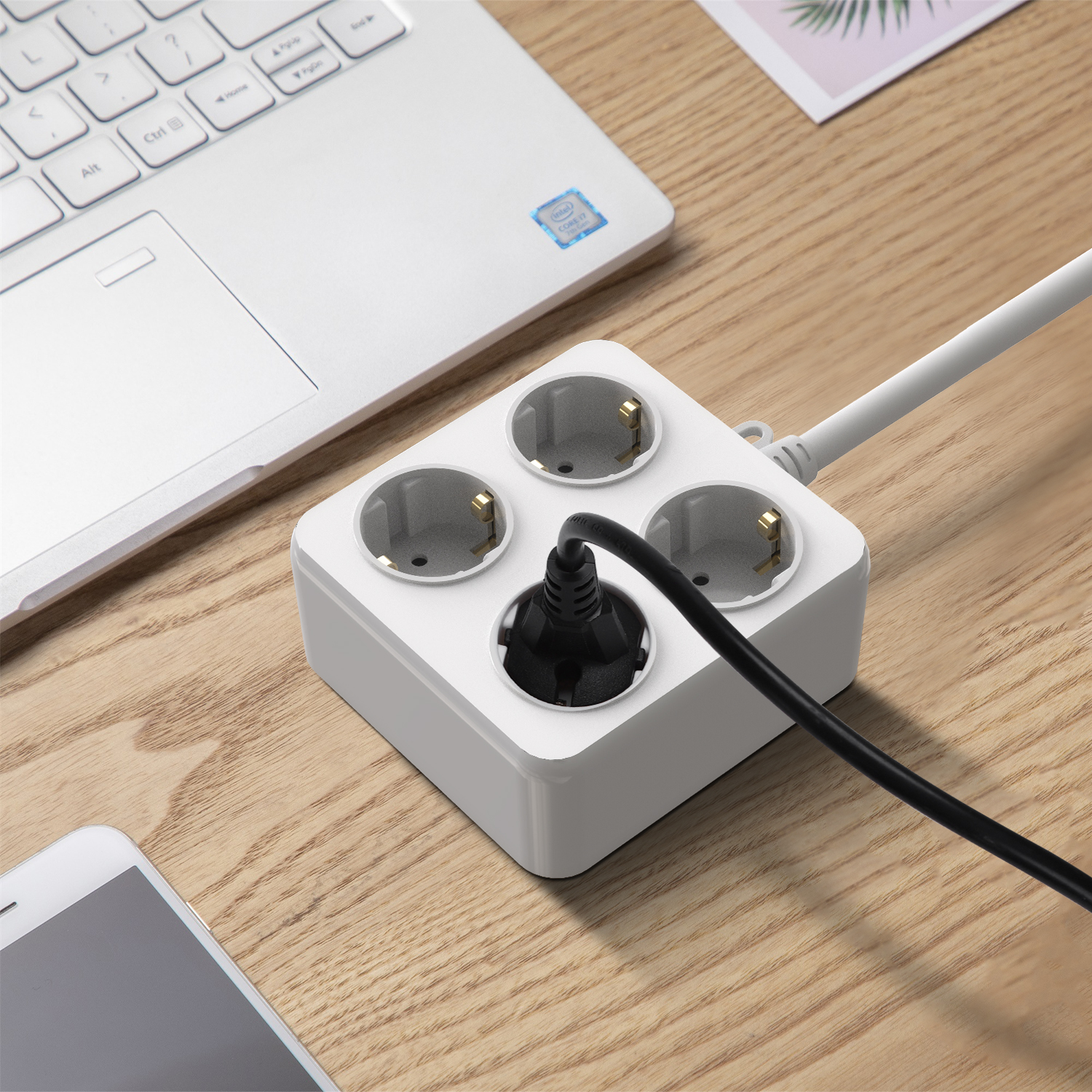 Weiße Steckdosenleiste mit vier Steckdosen, einem Stecker und einem Telefon. Hintergrund.