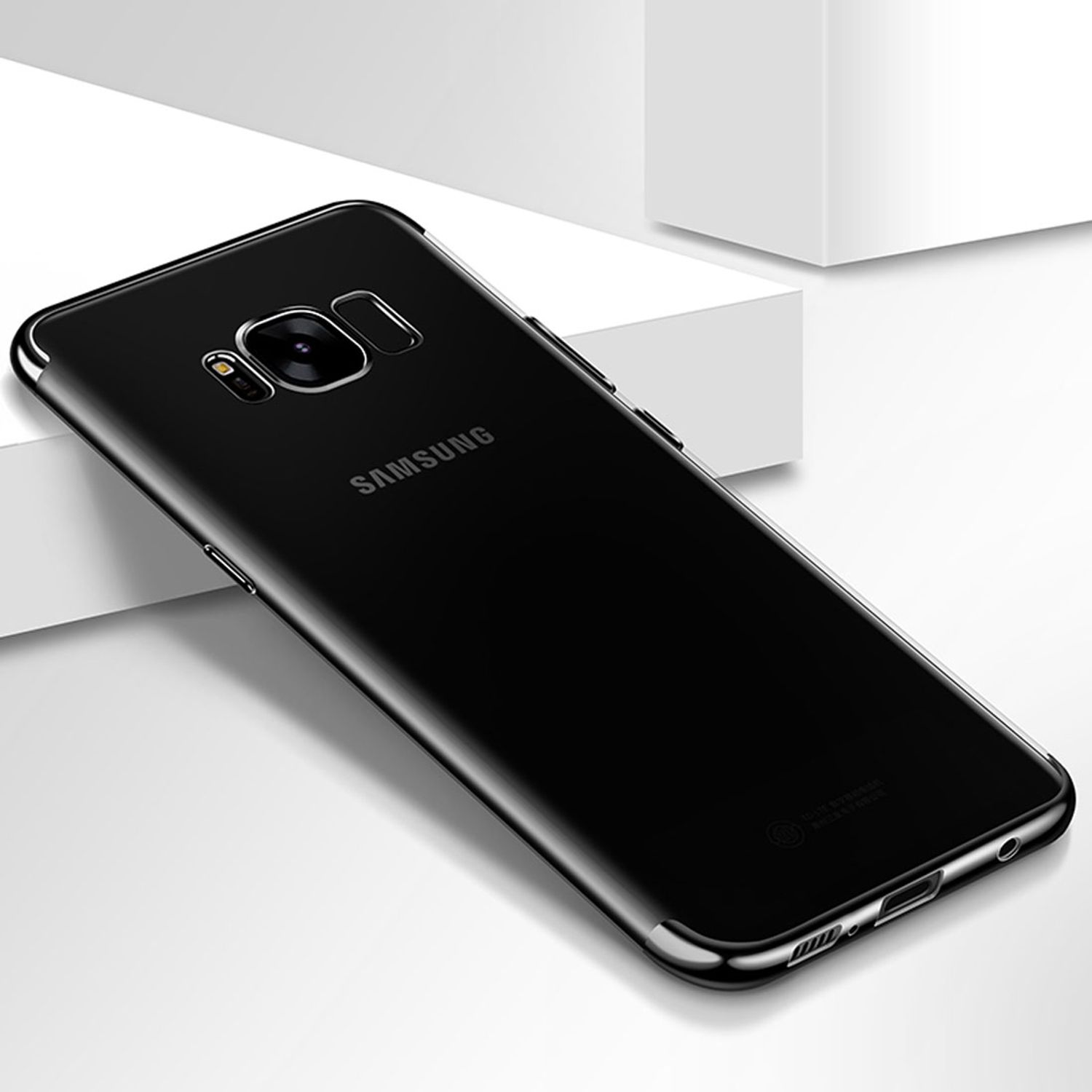 Schwarzes Telefon in einer transparenten Hülle. Das Telefon liegt auf weißem Untergrund.