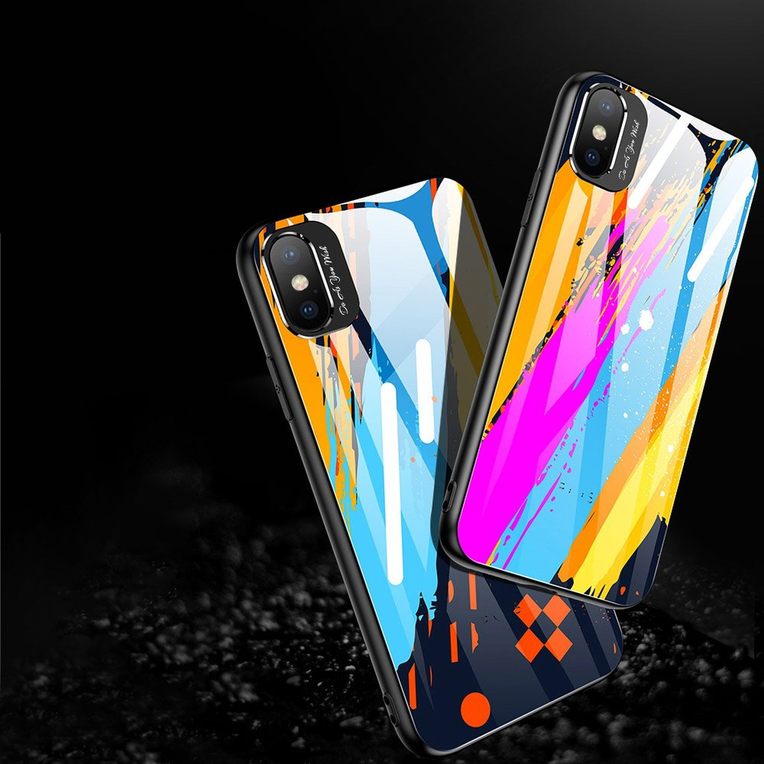 Zwei Telefone in bunten Hüllen. Schwarzer Hintergrund. Die Hüllen haben abstrakte Designs.