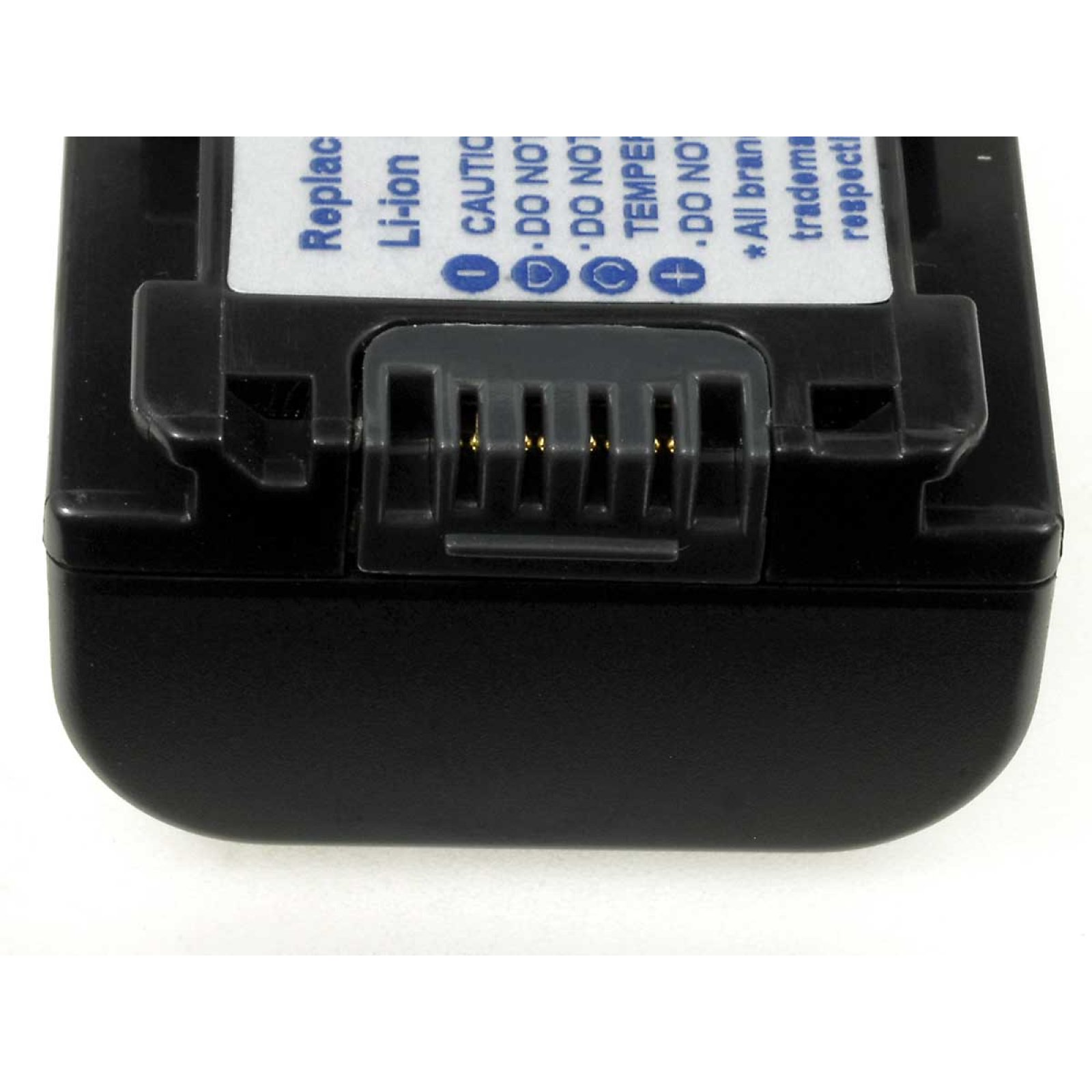 Primer plano de una batería negra con conector y etiqueta de advertencia.