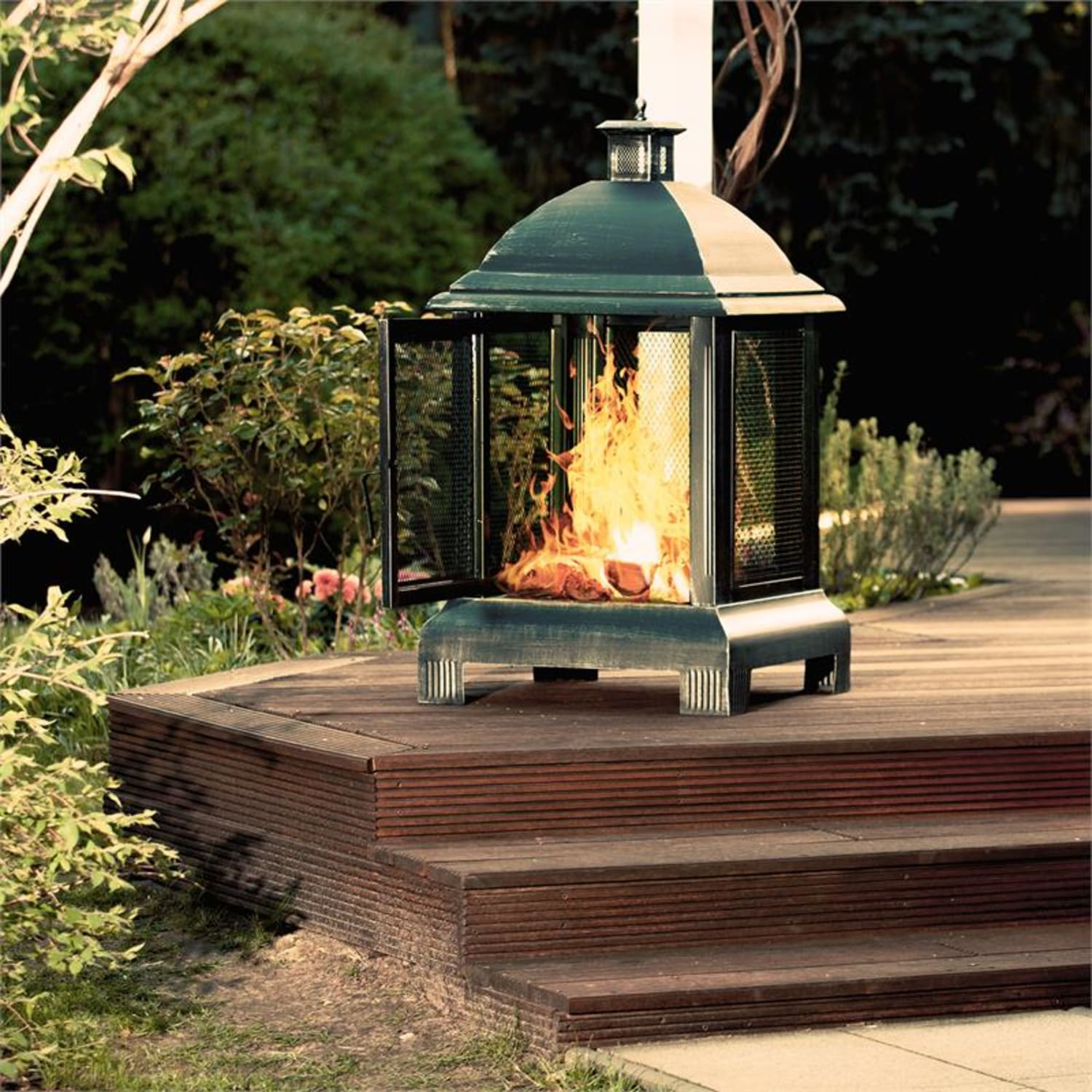 Outdoor-Kamin mit Flammen, offenen Türen und Holzterrasse.