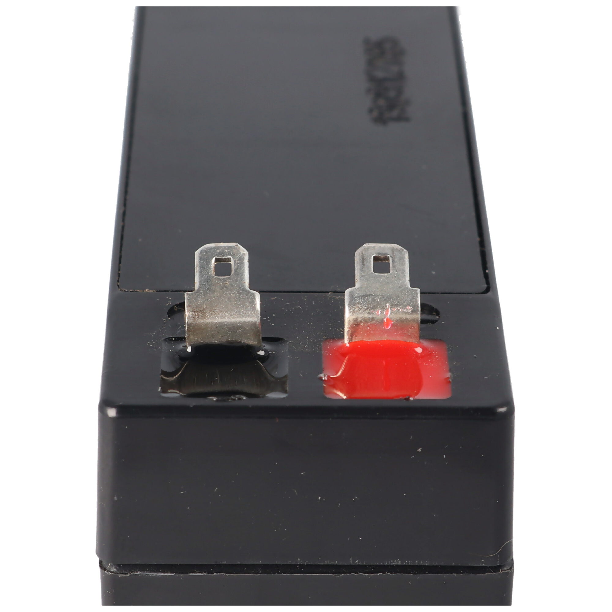 Schwarze Batterie mit silbernen Anschlüssen. Rot am rechten Anschluss. Weißer Hintergrund.