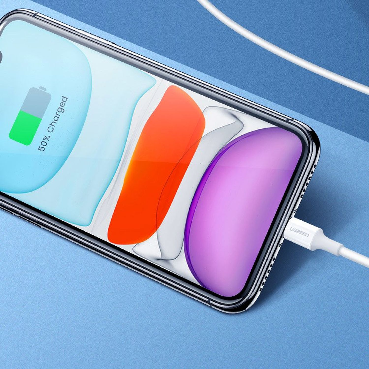 Telefon wird mit einem weißen Kabel geladen. Der Bildschirm zeigt an, dass der Akku zu 50 % geladen ist. Das Telefon befindet sich in einer durchsichtigen Hülle.