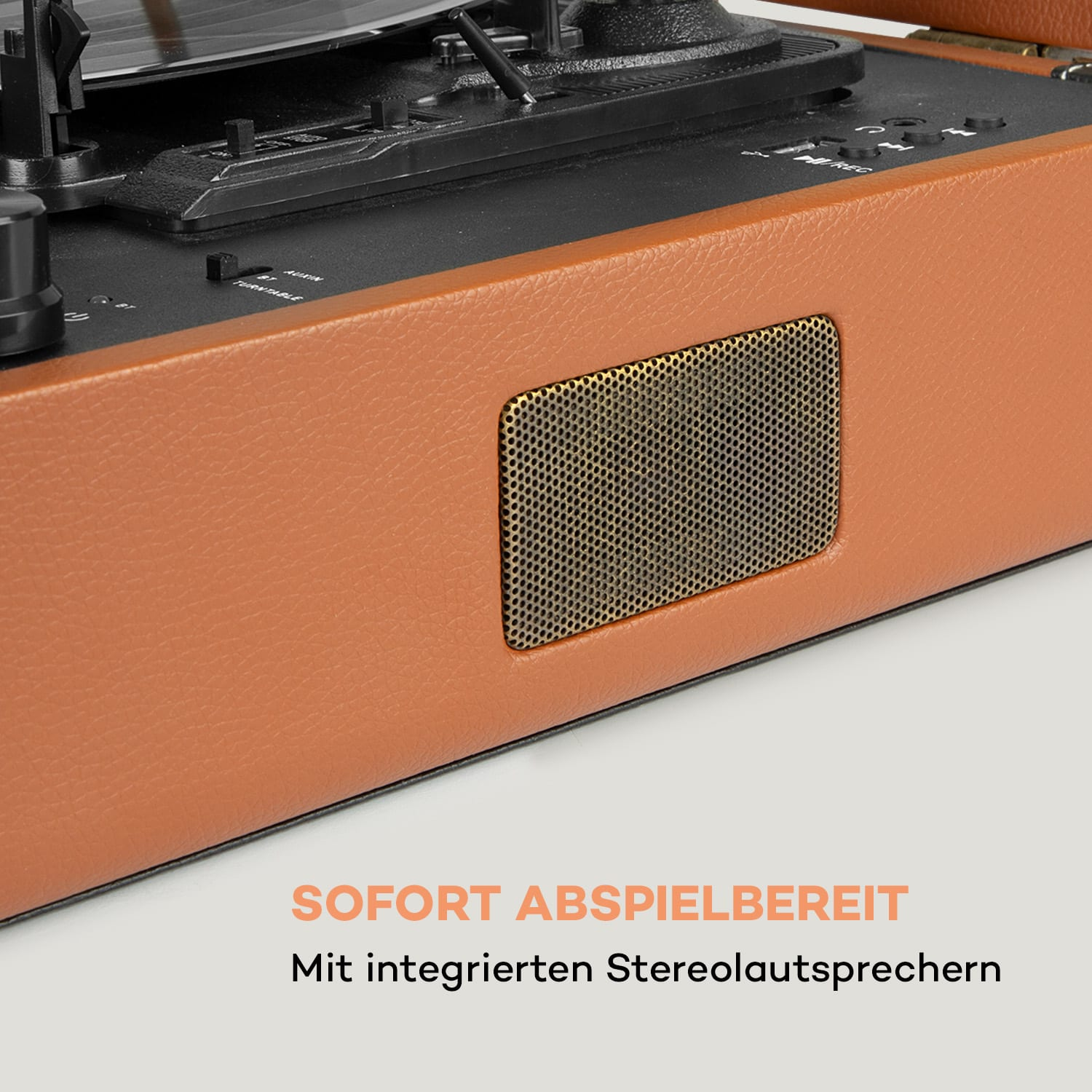 Brauner Retro-Plattenspieler mit Lautsprecher. Beigefarbener Hintergrund.