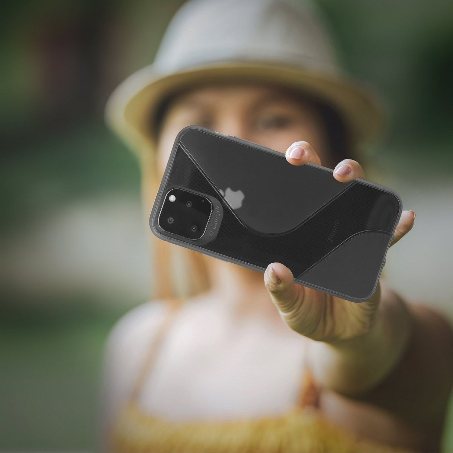 Person hält ein Telefon in einer durchsichtigen Hülle. Verschwommener Hintergrund.