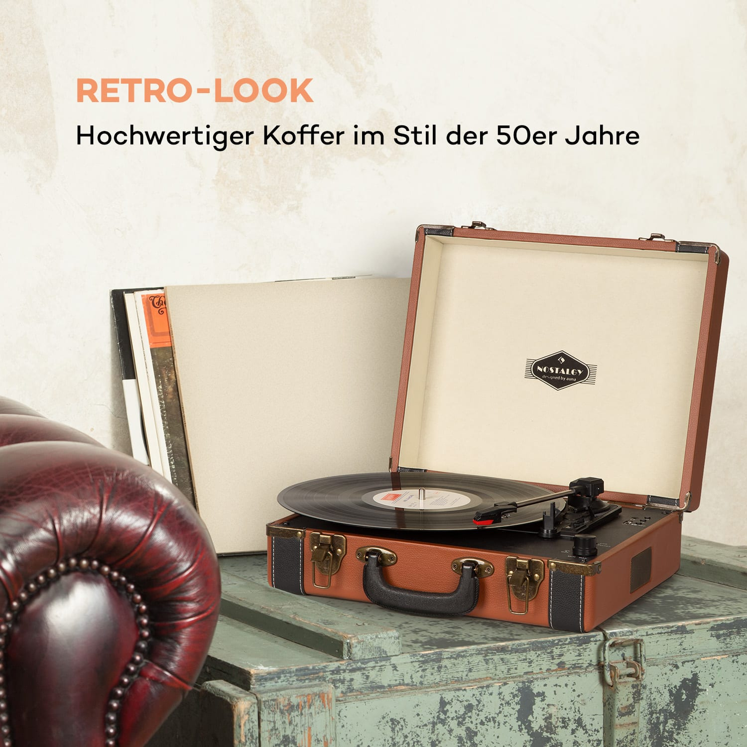 Retro-Plattenspieler auf einer Holzkiste. Brauner und schwarzer Player. Schallplatten und Buch liegen daneben.