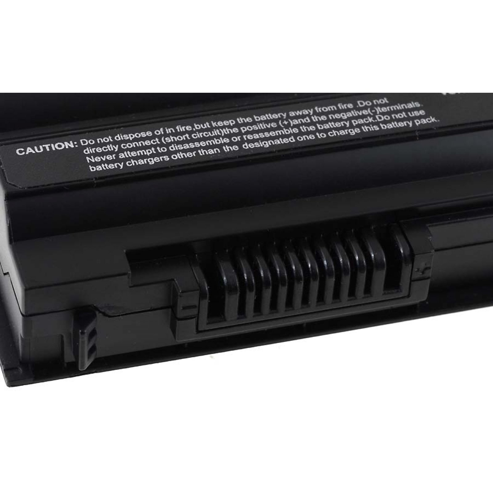Batería de portátil negra con texto de advertencia. Tiene una carcasa negra con ventilación y conector.