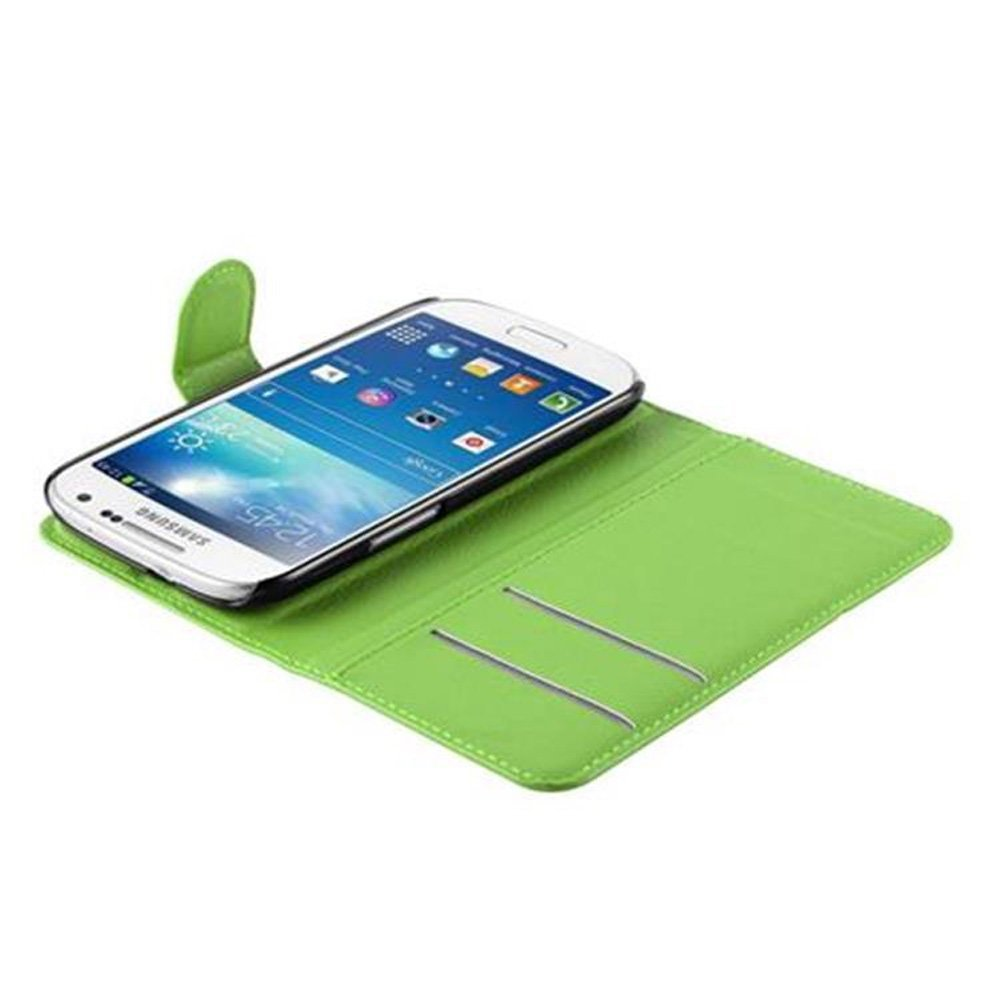 Una custodia verde per telefono con uno smartphone bianco all'interno. Il telefono mostra una schermata iniziale. Lo sfondo è verde.