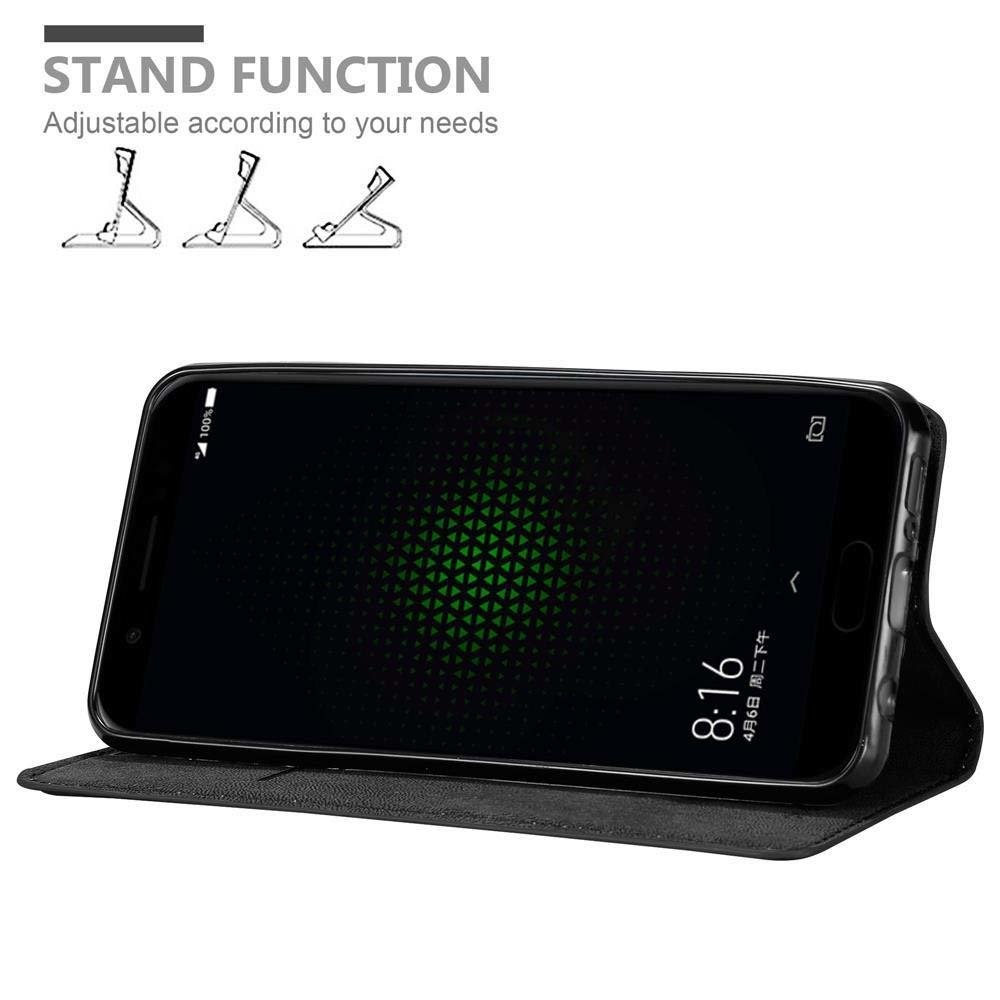 Schwarzes Telefon in einer Standhülle, zeigt die Uhrzeit 8:16 auf dem Bildschirm.