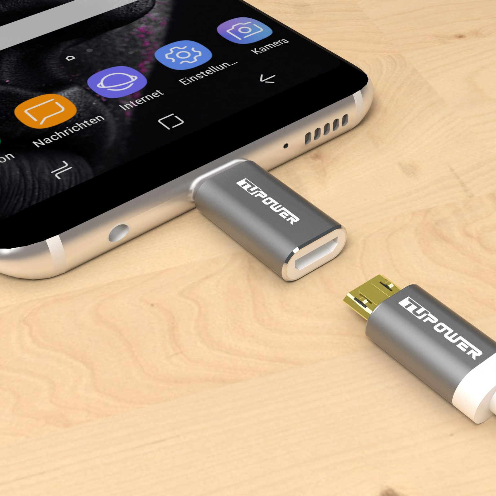 Ein Telefon ist mit zwei grauen USB-C-Adaptern verbunden. Das Telefon und die Adapter befinden sich auf einer Holzoberfläche.