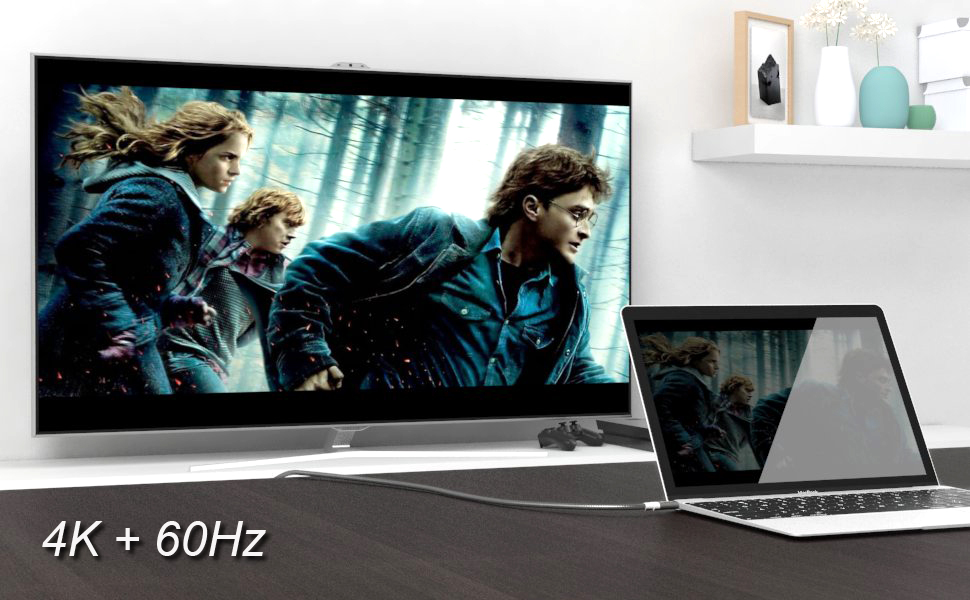 Ein Laptop, der einen Film anzeigt, über ein Kabel mit einem Fernseher verbunden.