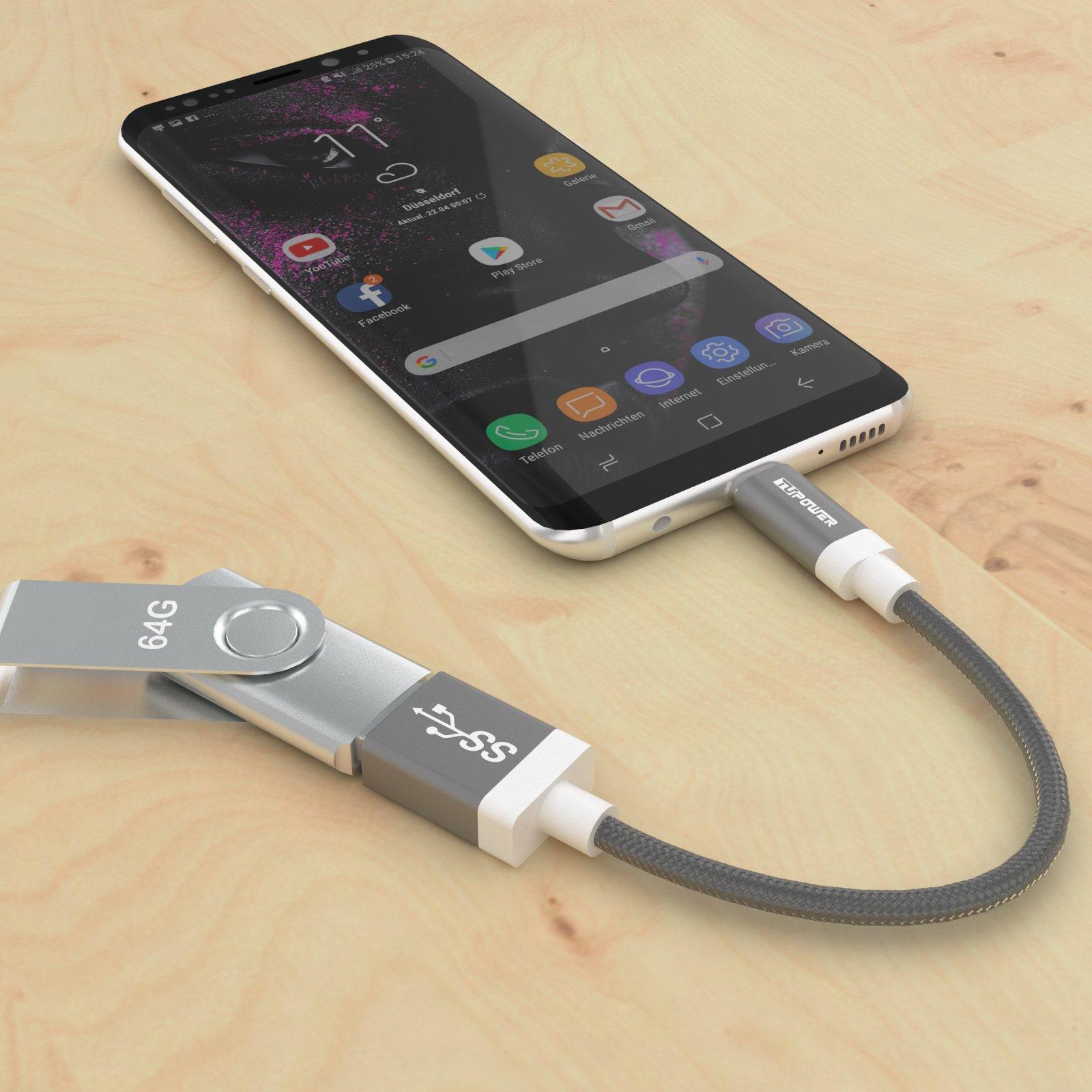 Smartphone über ein Kabel mit einem USB-Laufwerk verbunden, auf einer Holzoberfläche.