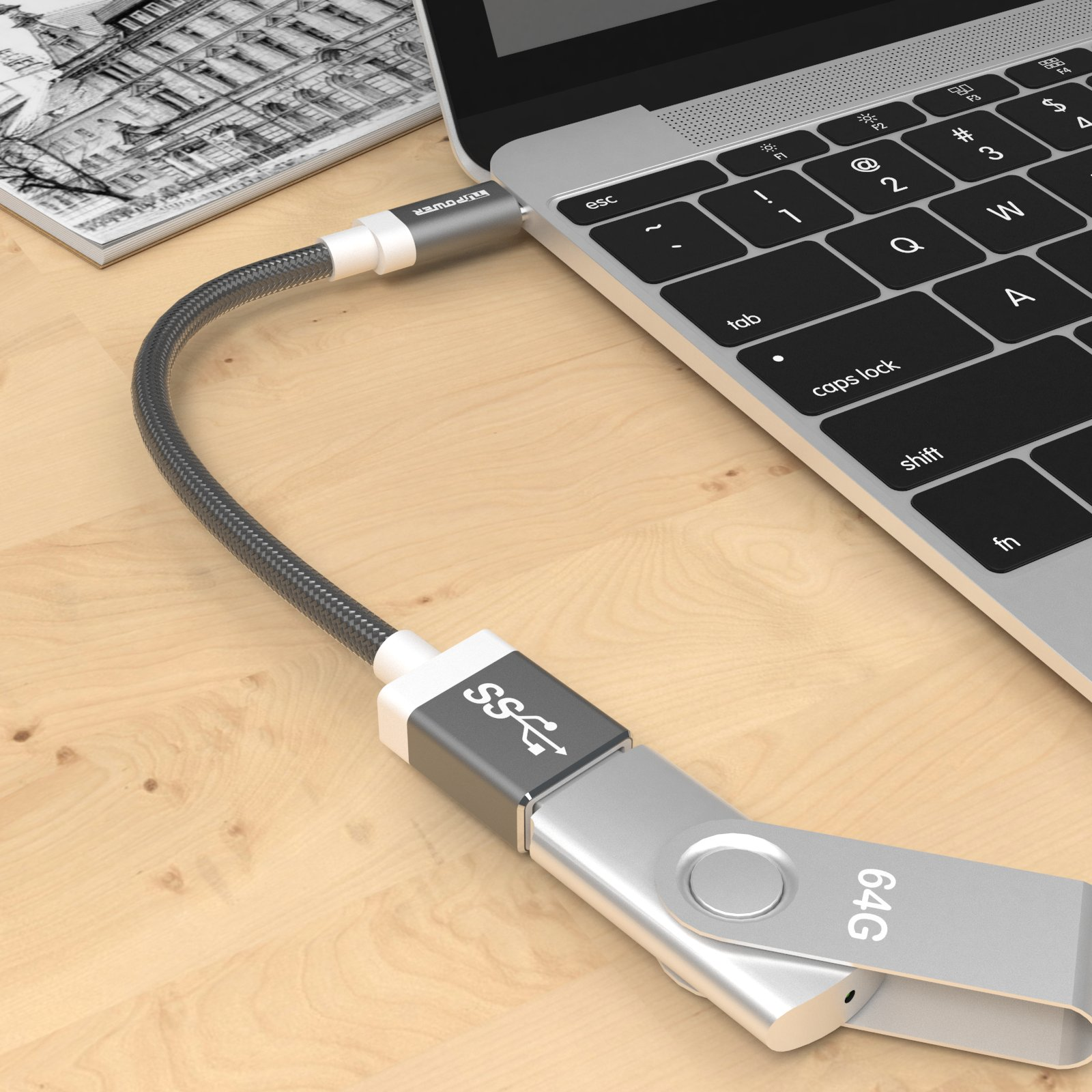 USB-C-Kabel an Laptop angeschlossen und silberner USB-Stick auf Holzoberfläche.