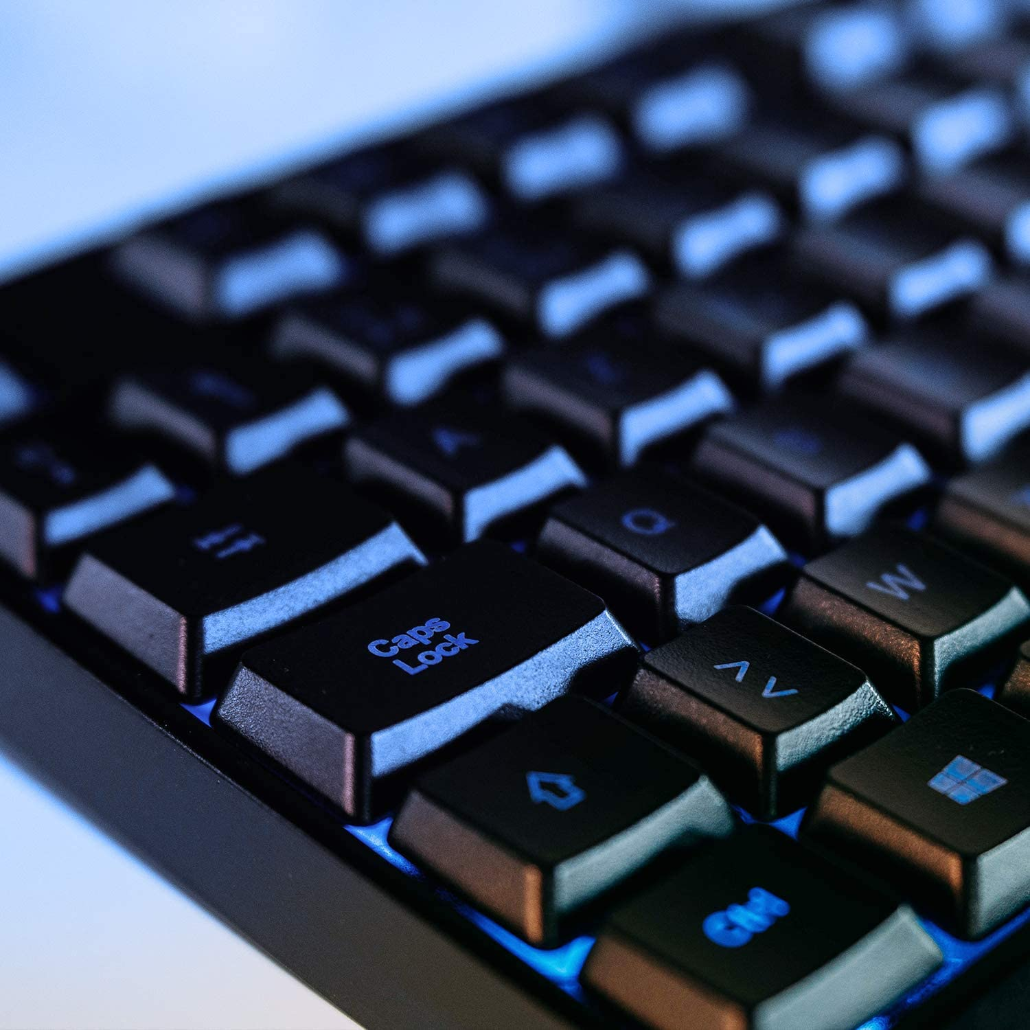 Eine Nahaufnahme einer schwarzen mechanischen Tastatur mit blauer Hintergrundbeleuchtung.