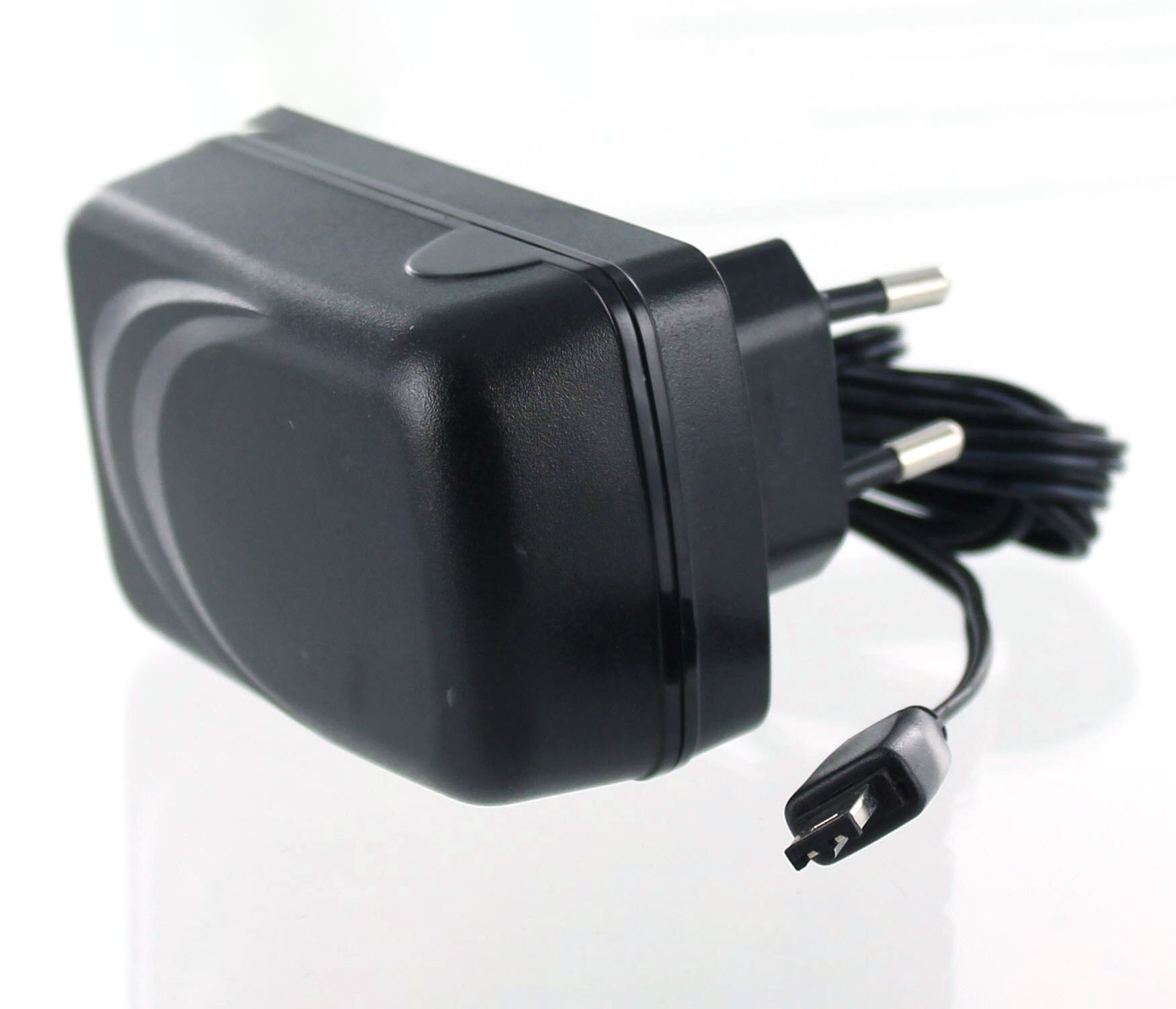 Schwarzer AC-Adapter mit schwarzem Kabel und einem zweipoligen Stecker auf weißer Oberfläche. Der Adapter hat eine gebogene Form.