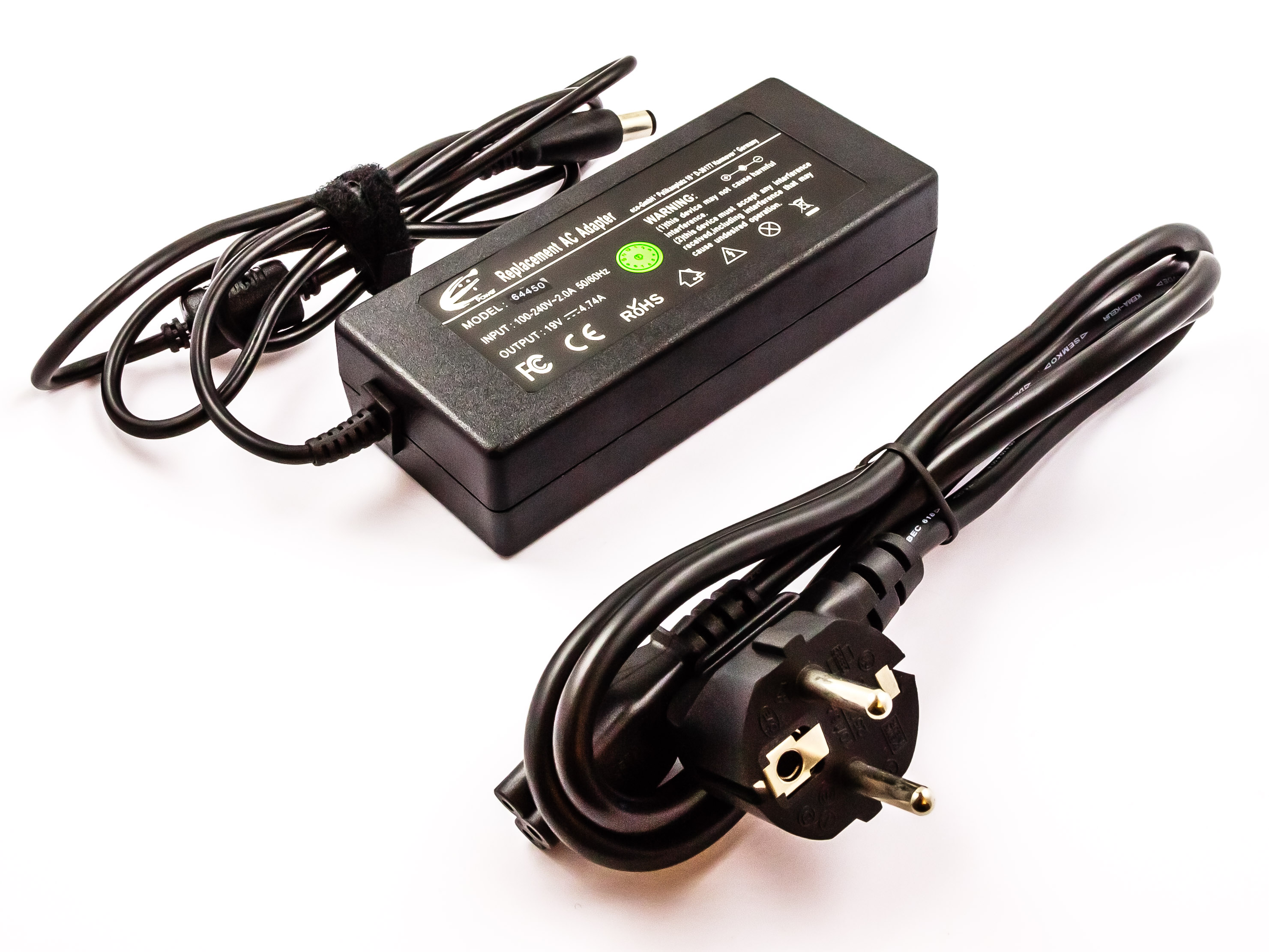 Schwarzes Netzteil und schwarze Kabel mit Stecker. Das Bild vor weißem Hintergrund.