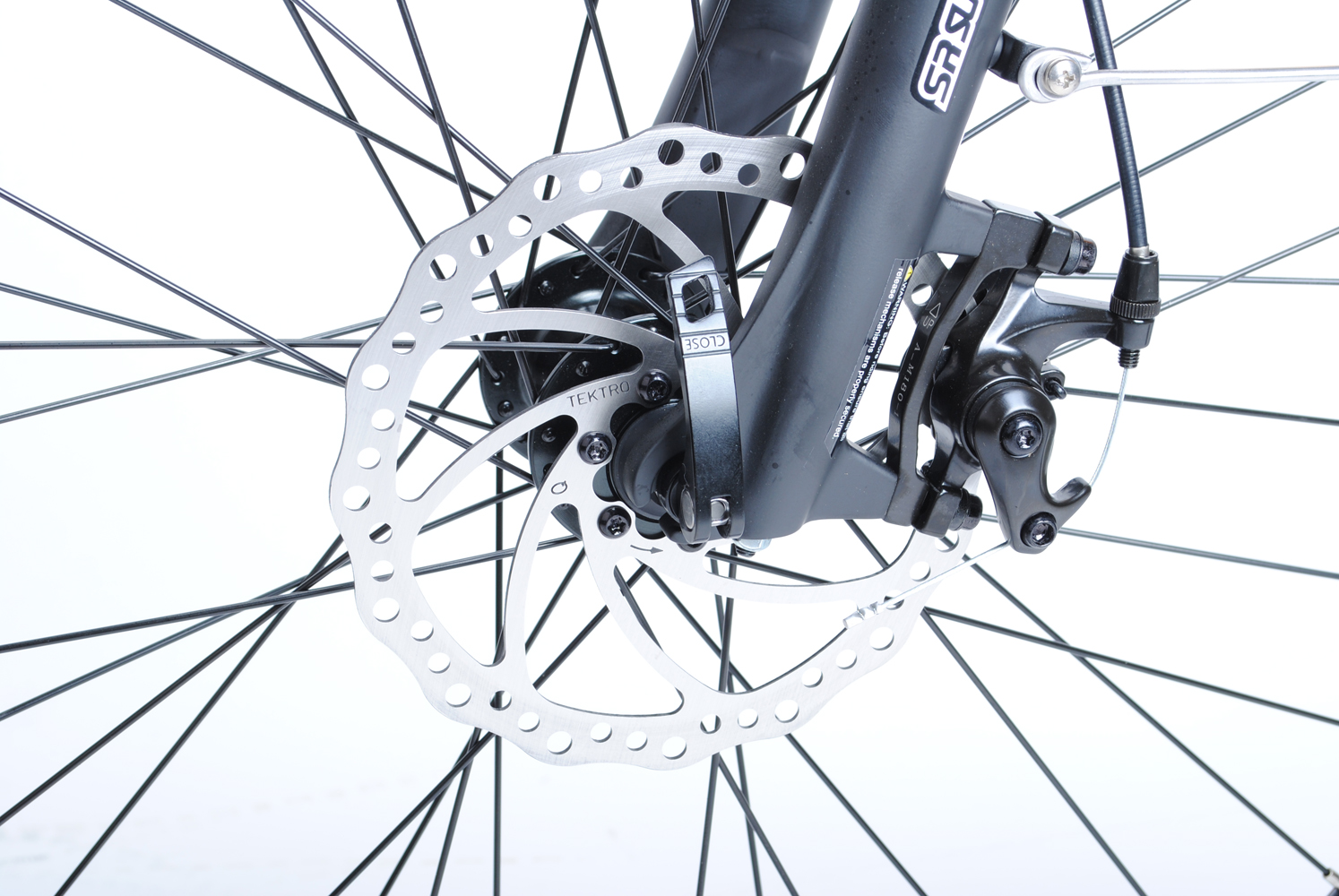 Nahaufnahme einer Fahrradscheibenbremse. Silberne Scheibe, schwarzer Bremssattel, Speichen. Weißer Hintergrund.