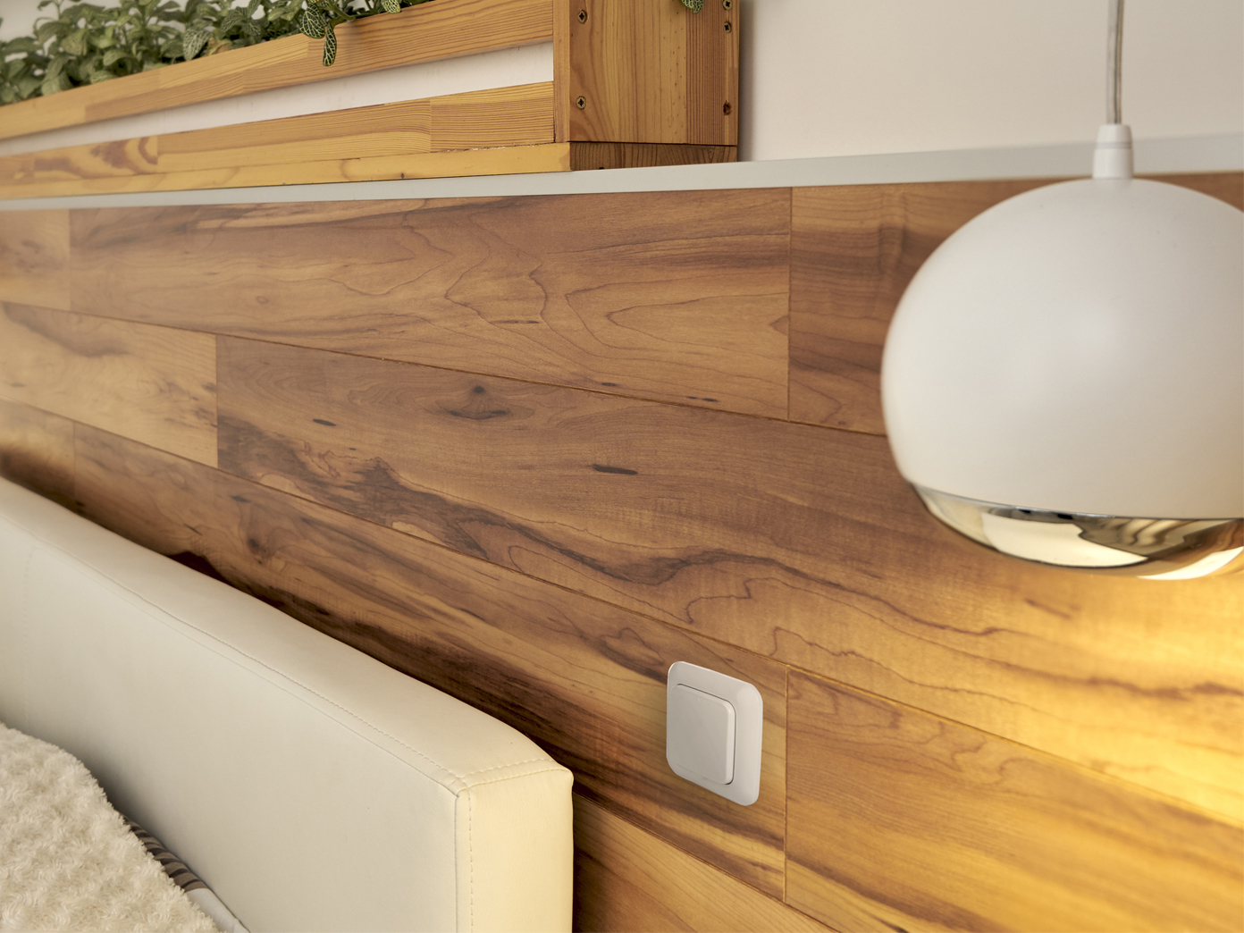 Kopfende mit Holzpaneelen mit weißem Bett und einer Pendelleuchte.