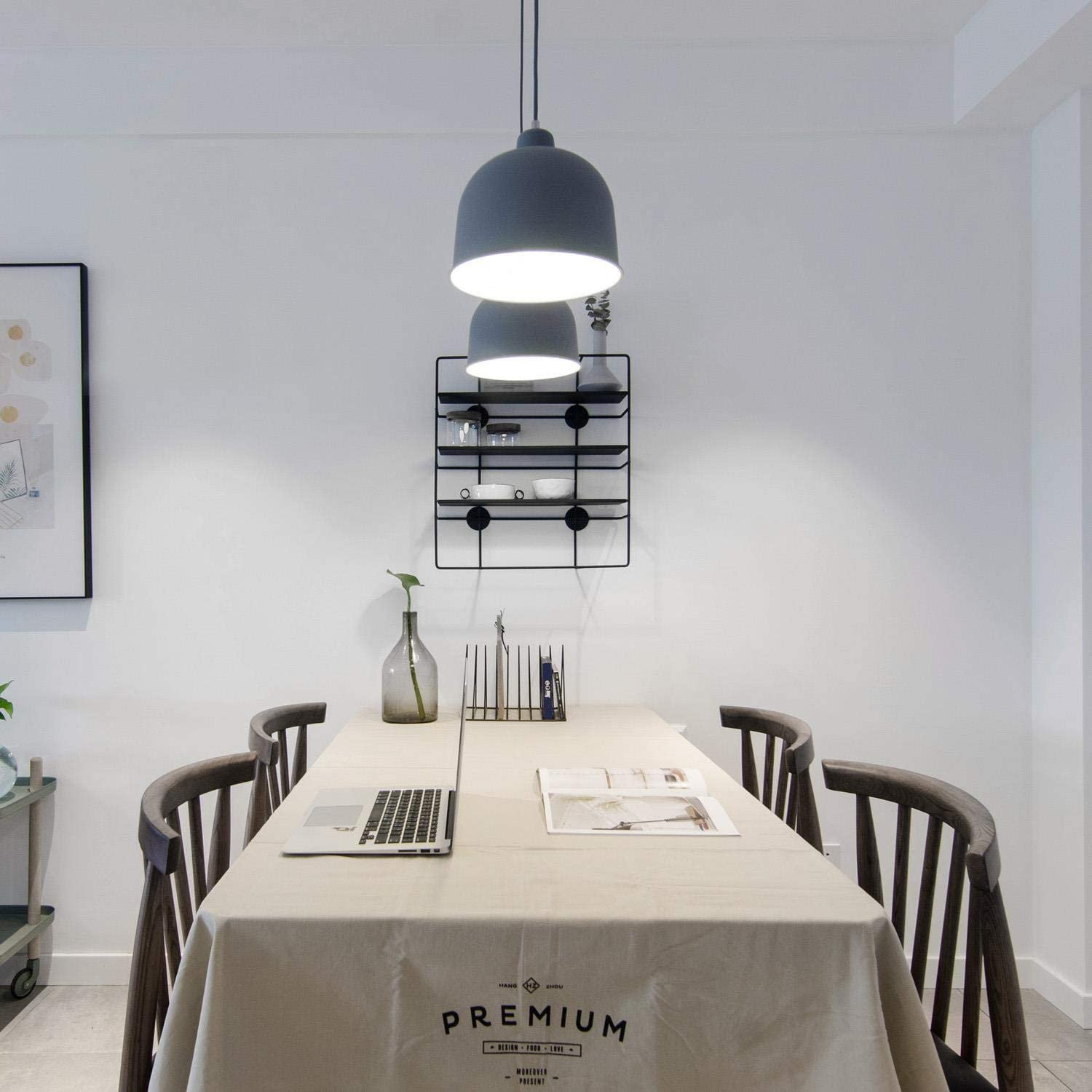 Un tavolo da pranzo con tovaglia di lino, laptop e due sedie in legno.