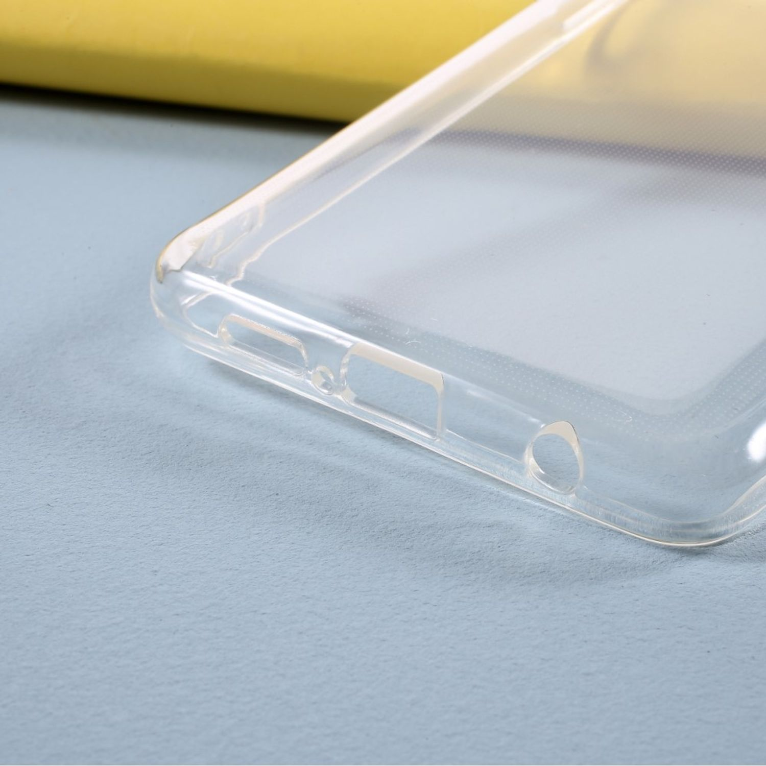 Nahaufnahme einer transparenten Handyhülle mit Aussparung für einen Anschluss und einem kleinen Loch.