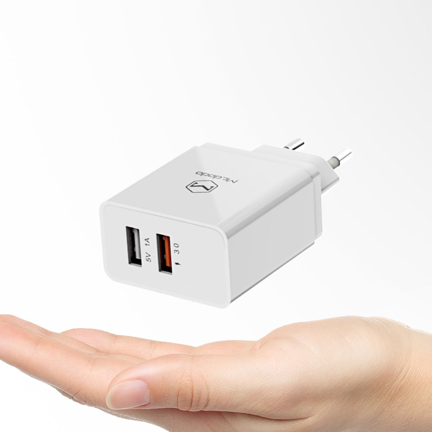 Ein weißes Ladegerät mit zwei USB-Anschlüssen, gehalten in einer Hand.