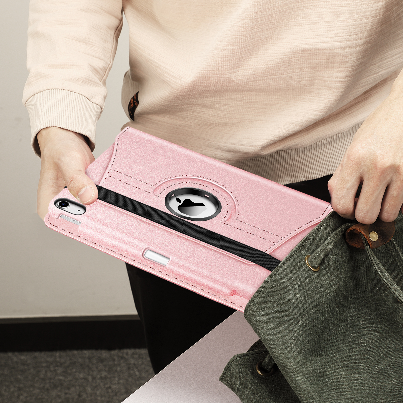 Eine Person hält eine rosa Tablet-Hülle mit schwarzem Riemen und einem Stift.