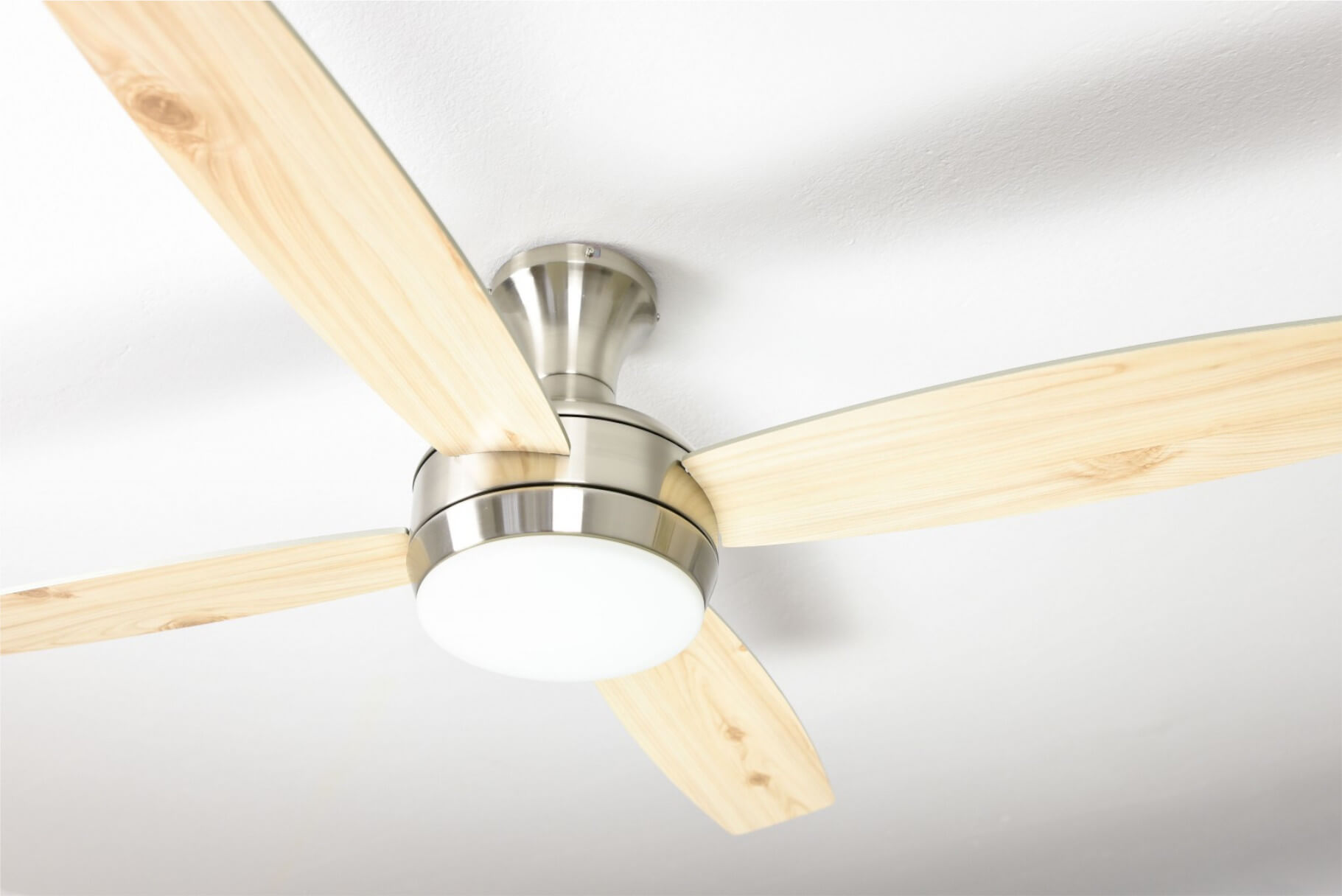Un ventilatore da soffitto con tre pale in legno e un alloggiamento motore argentato.