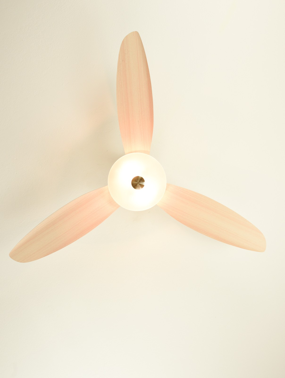 Deckenventilator mit drei rosafarbenen Flügeln und einer zentralen Leuchte.