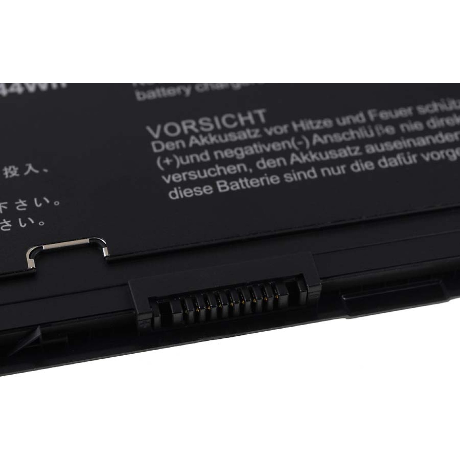 Primer plano de una batería negra de portátil con texto de advertencia en alemán y un conector.