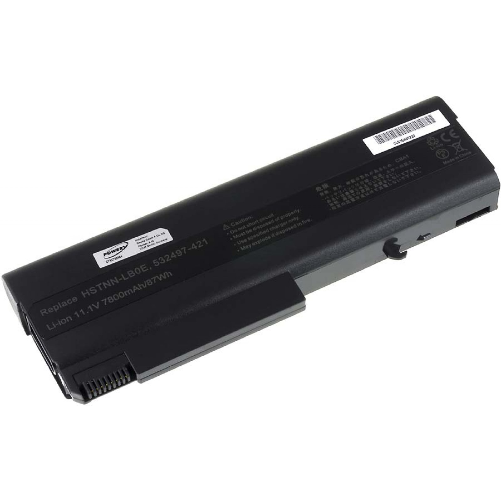 Una batería negra de laptop con etiqueta y conector, sobre una superficie blanca.
