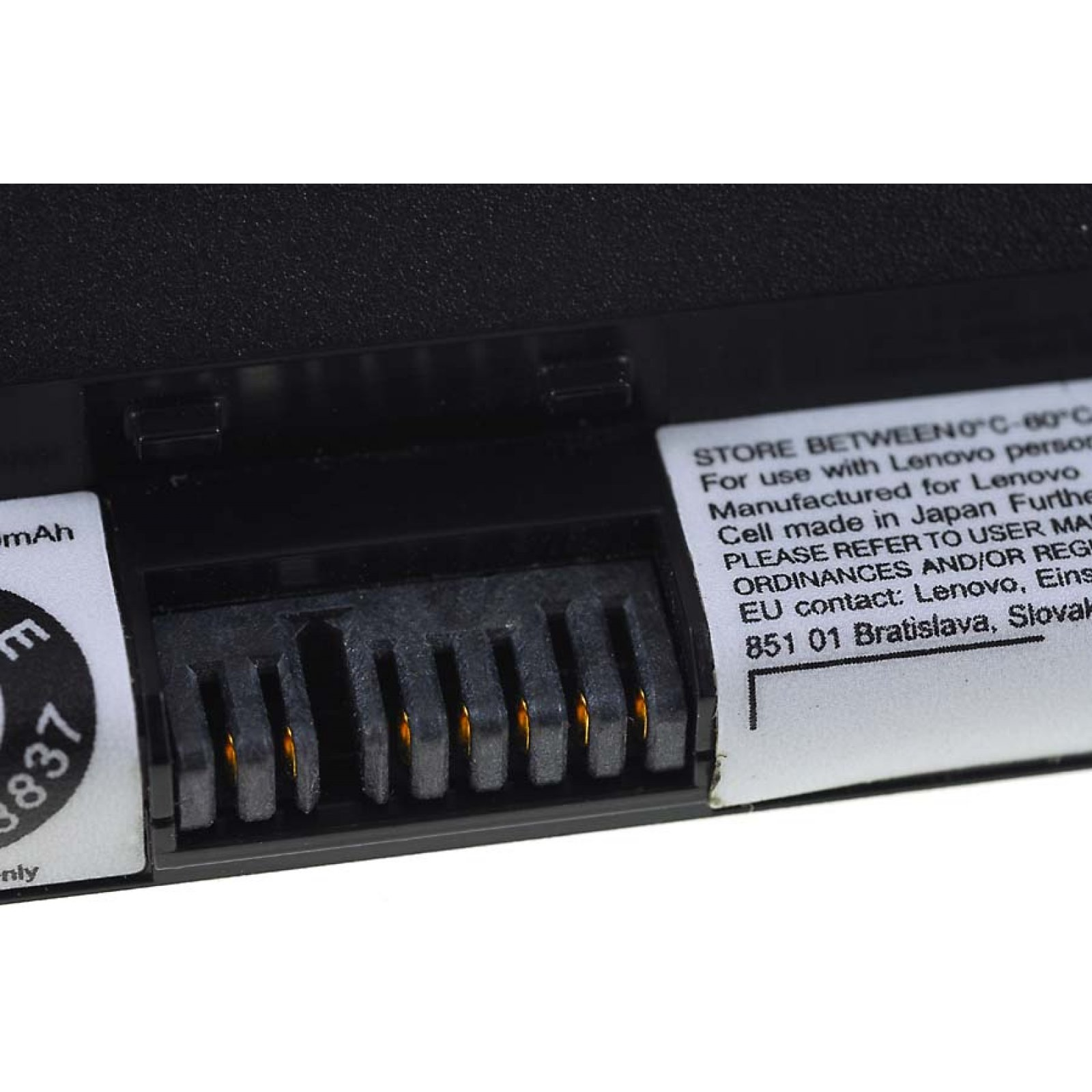 Primer plano de un conector de batería con pines dorados y una etiqueta con texto.
