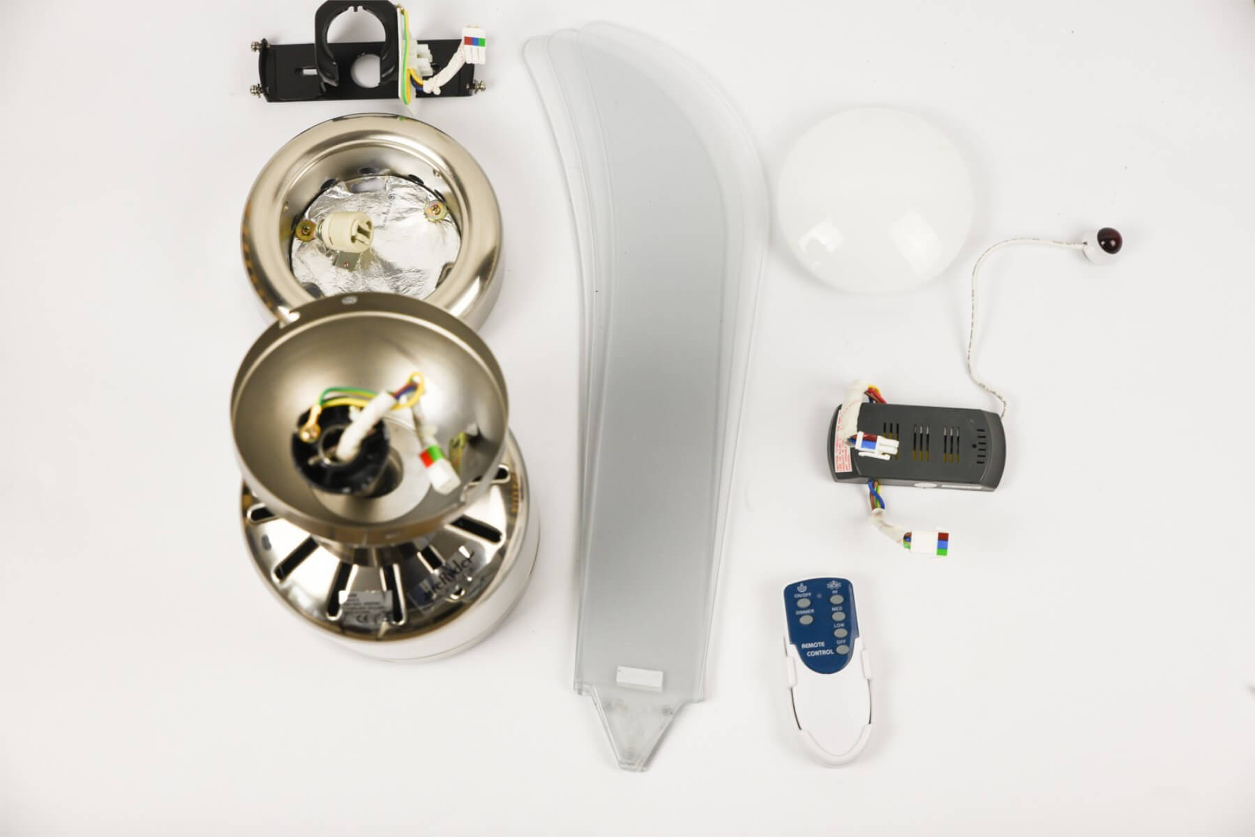 Zerlegter Deckenventilator mit Teilen auf einer weißen Oberfläche verteilt.