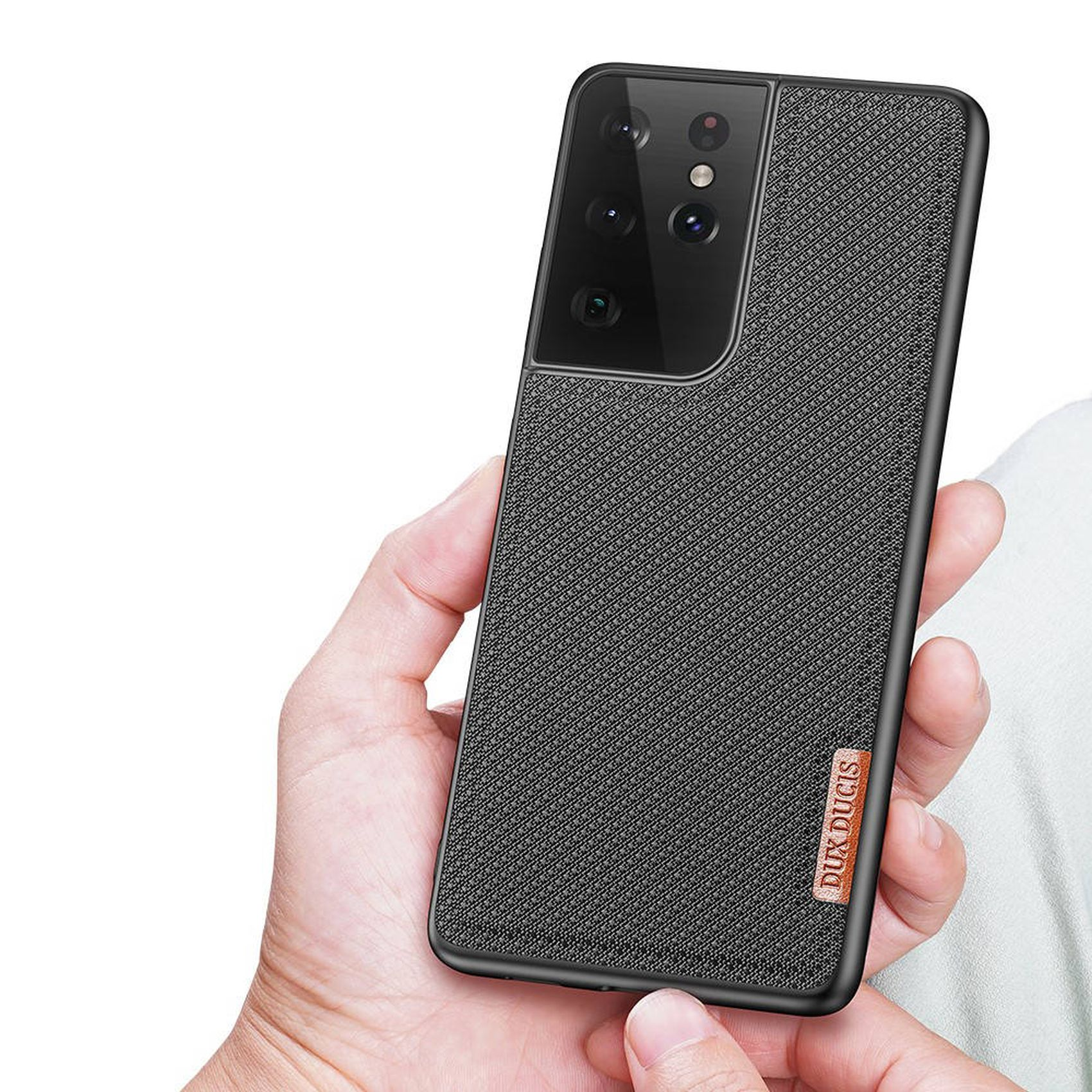 Schwarzes Telefon in einer Hülle in der Hand gehalten. Die Hülle hat ein strukturiertes Muster und ein Markenetikett.