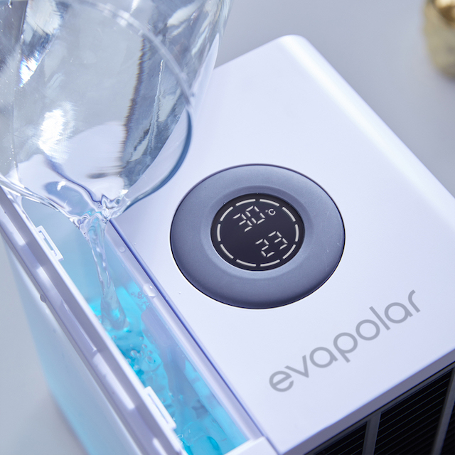 Wasser gießt in ein weißes Gerät mit digitaler Temperaturanzeige.