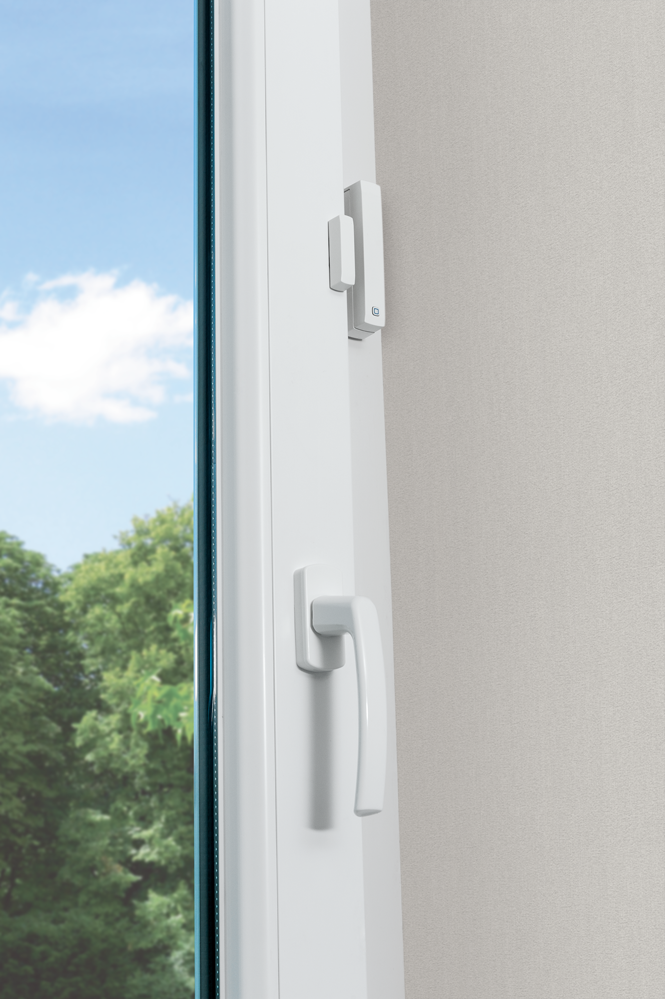 Białe okno z uchwytem i zamkiem, oprawione na tle nieba i ściany.