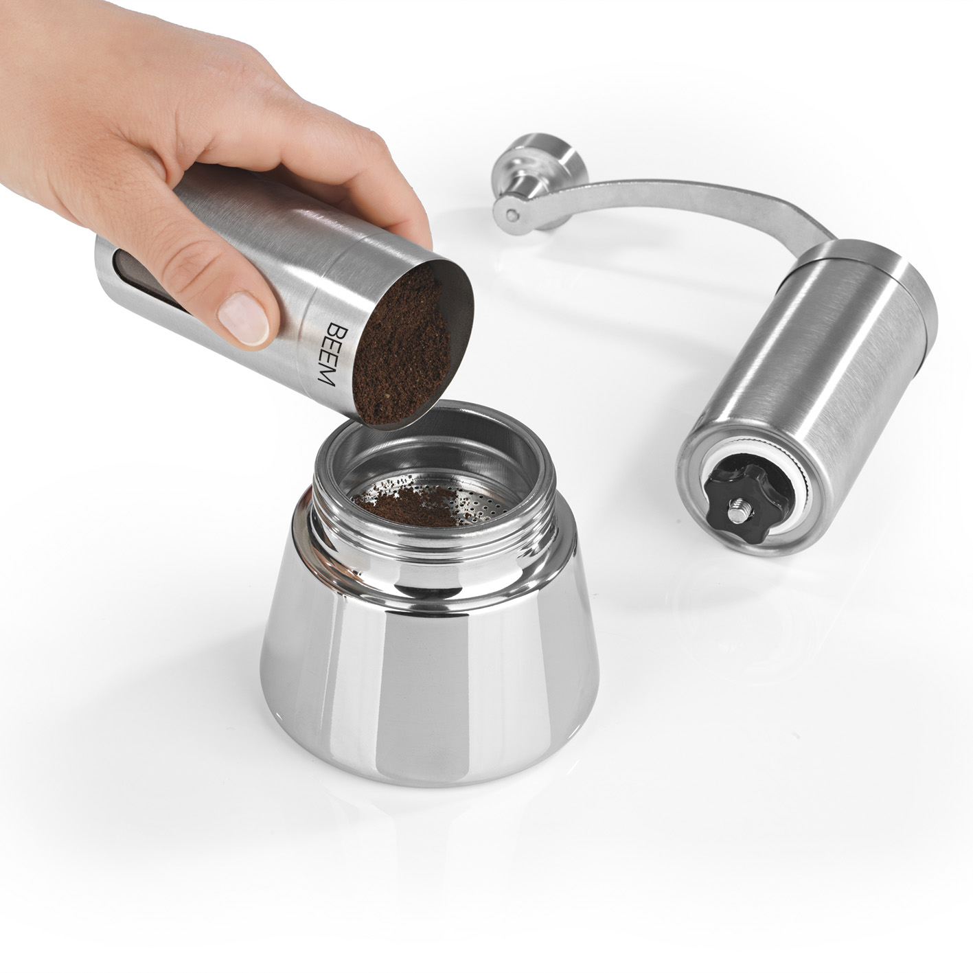 Person gießt gemahlenen Kaffee in eine Kaffeemaschine.