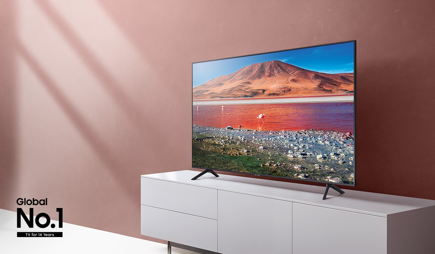 TV mit Landschaftsszene auf einem weißen Schrank vor einer pfirsichfarbenen Wand mit dem Text "Global Nr. 1 TV seit 14 Jahren".