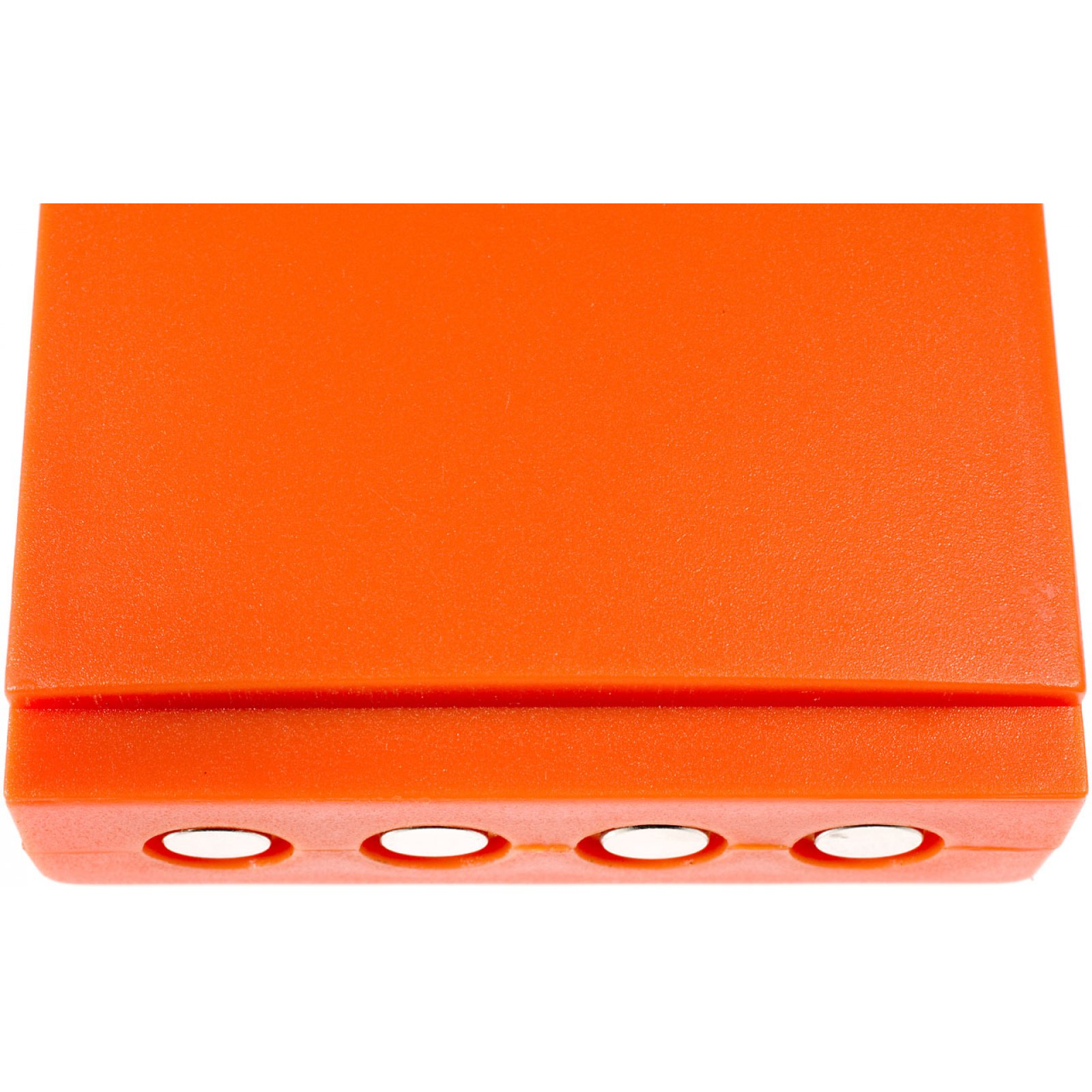 Dispositivo de plástico naranja con cuatro agujeros. Vista superior, fondo blanco liso.