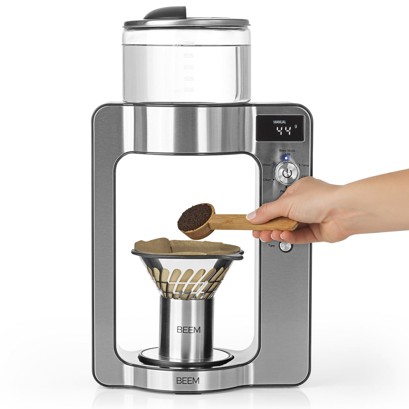Macchina per il caffè con un cucchiaio di legno che aggiunge caffè macinato a un filtro. Parti in vetro e metallo.