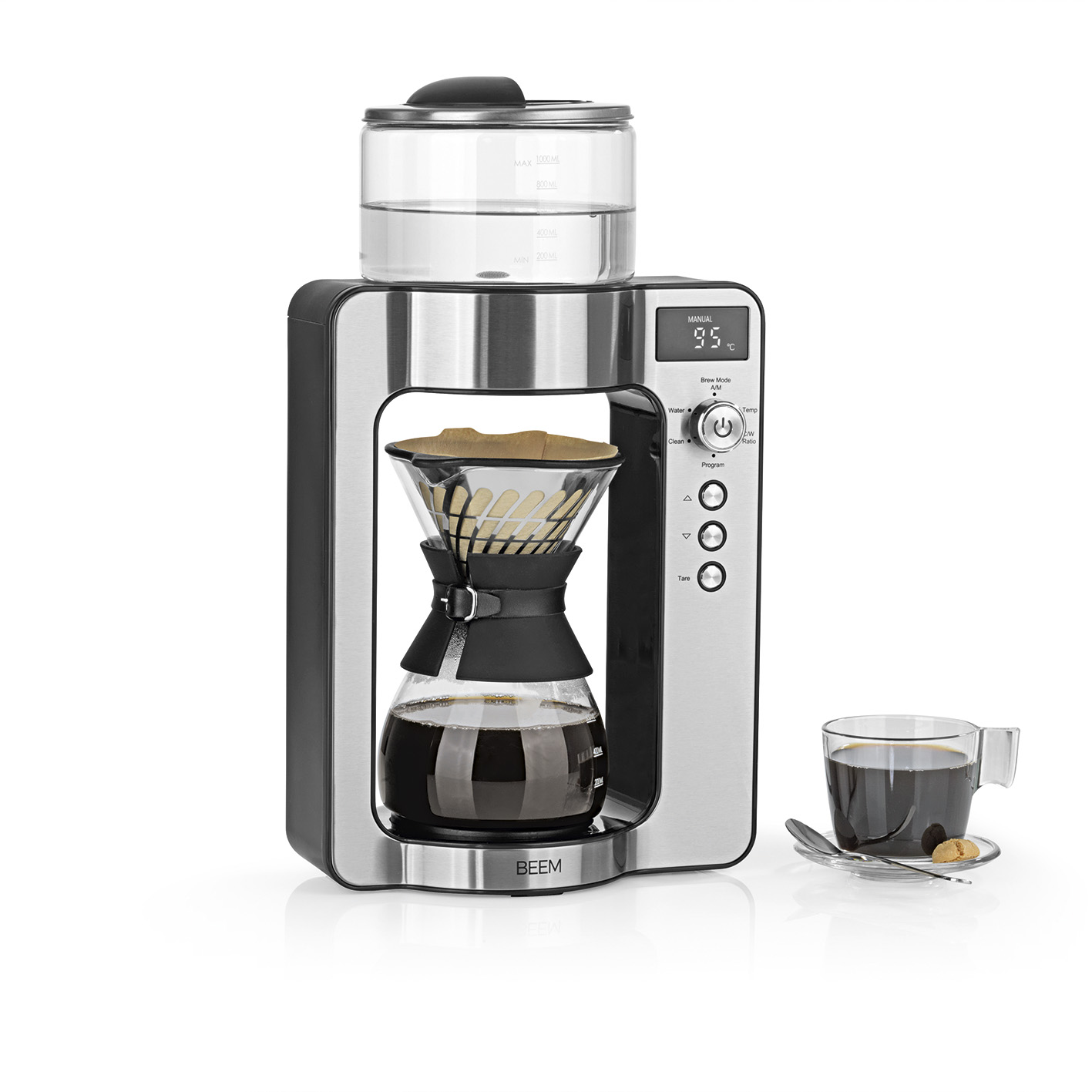 Una macchina per il caffè con caraffa in vetro, una tazza di caffè e un cucchiaio. Lo sfondo è bianco.